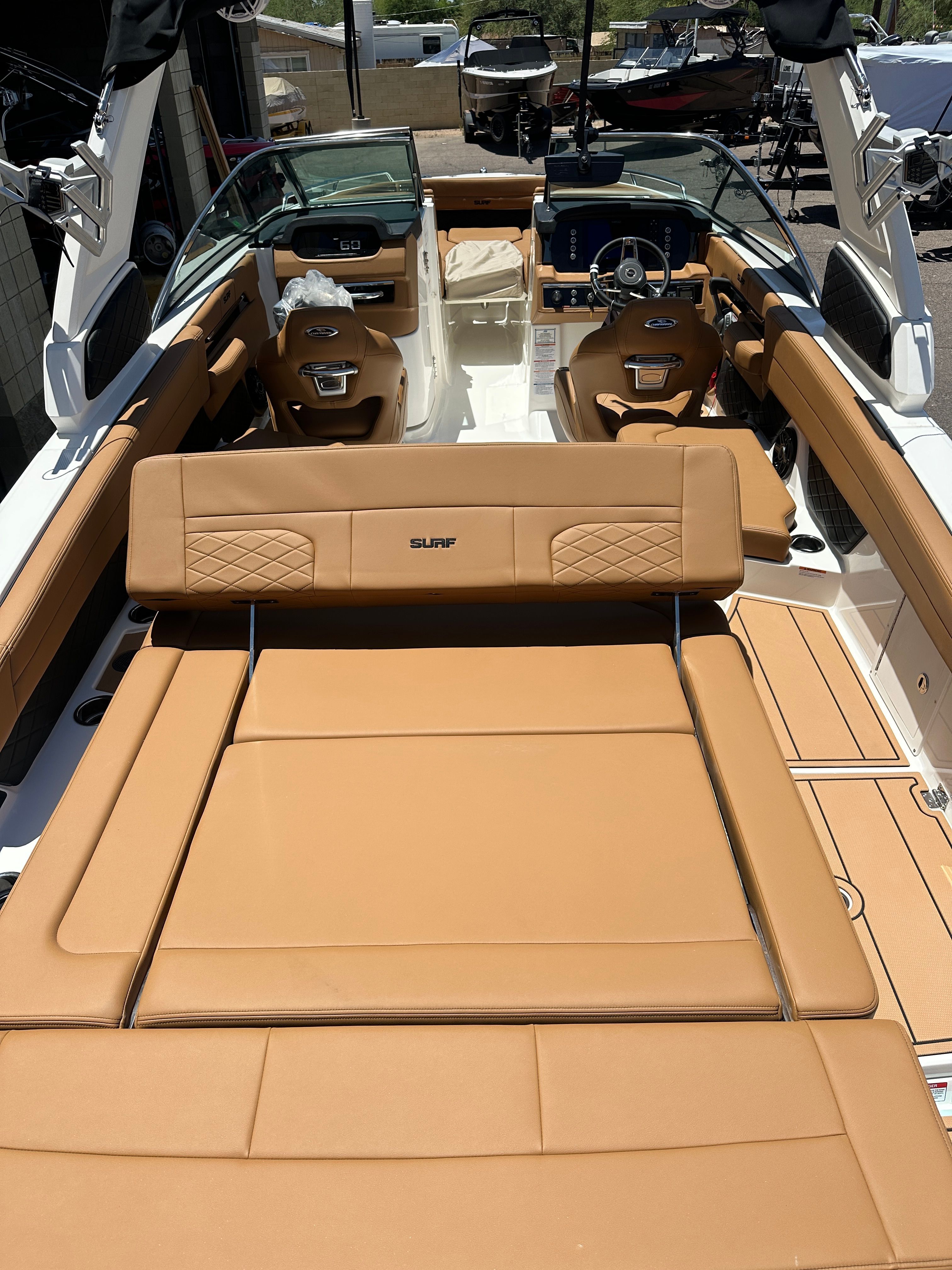 The image shows the interior of a 2025 Chaparral 26 Surf boat with brown leather seating.