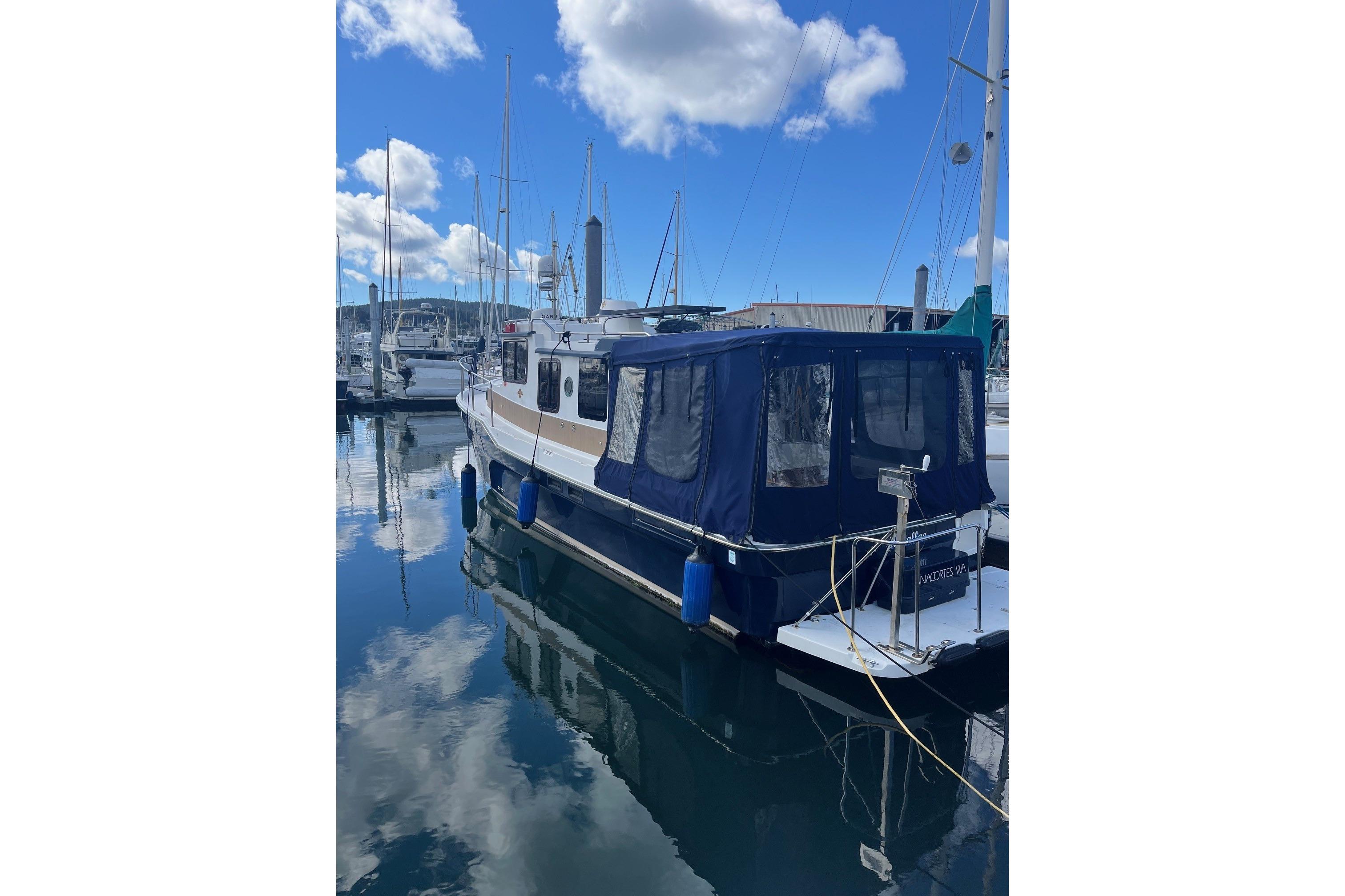 2015 Ranger Tugs R-31 S docked at marina under blue sky.