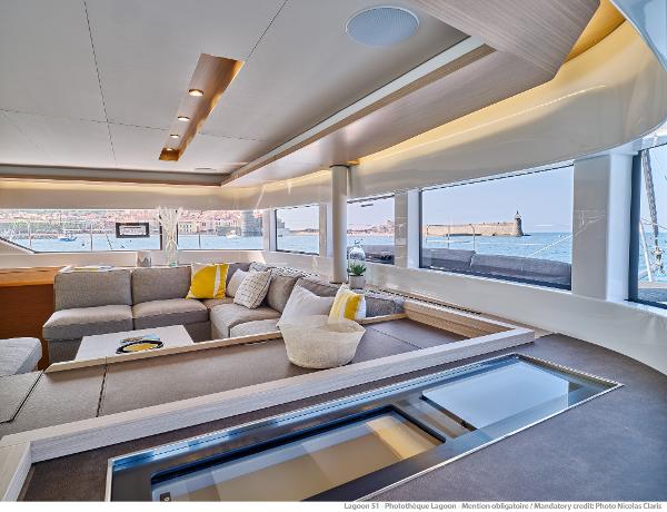 Luxurious interior of 2025 Lagoon 51 ICONIC yacht with panoramic windows and modern furnishings.