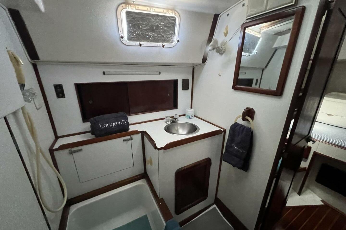 1981 Morgan 462 yacht bathroom with sink, mirror, and storage cabinets.