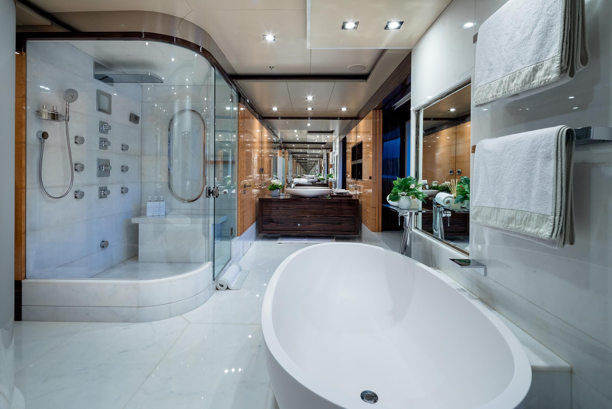 Luxurious Benetti 60 yacht bathroom, 2011 model, featuring elegant bathtub and glass shower.