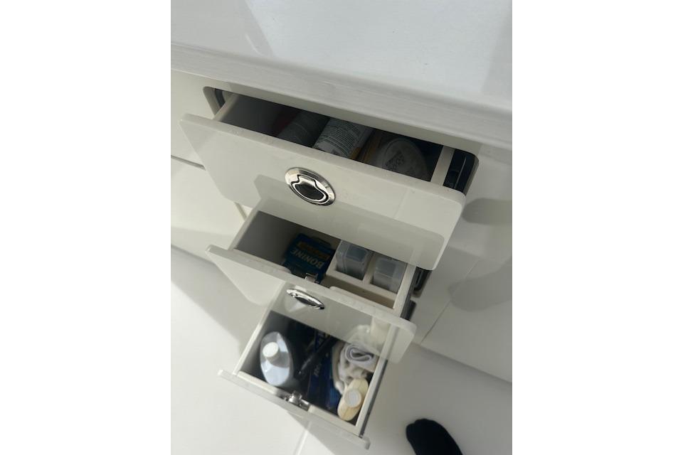 Open drawers on a 2022 Regal 38 SAV boat, containing various items.