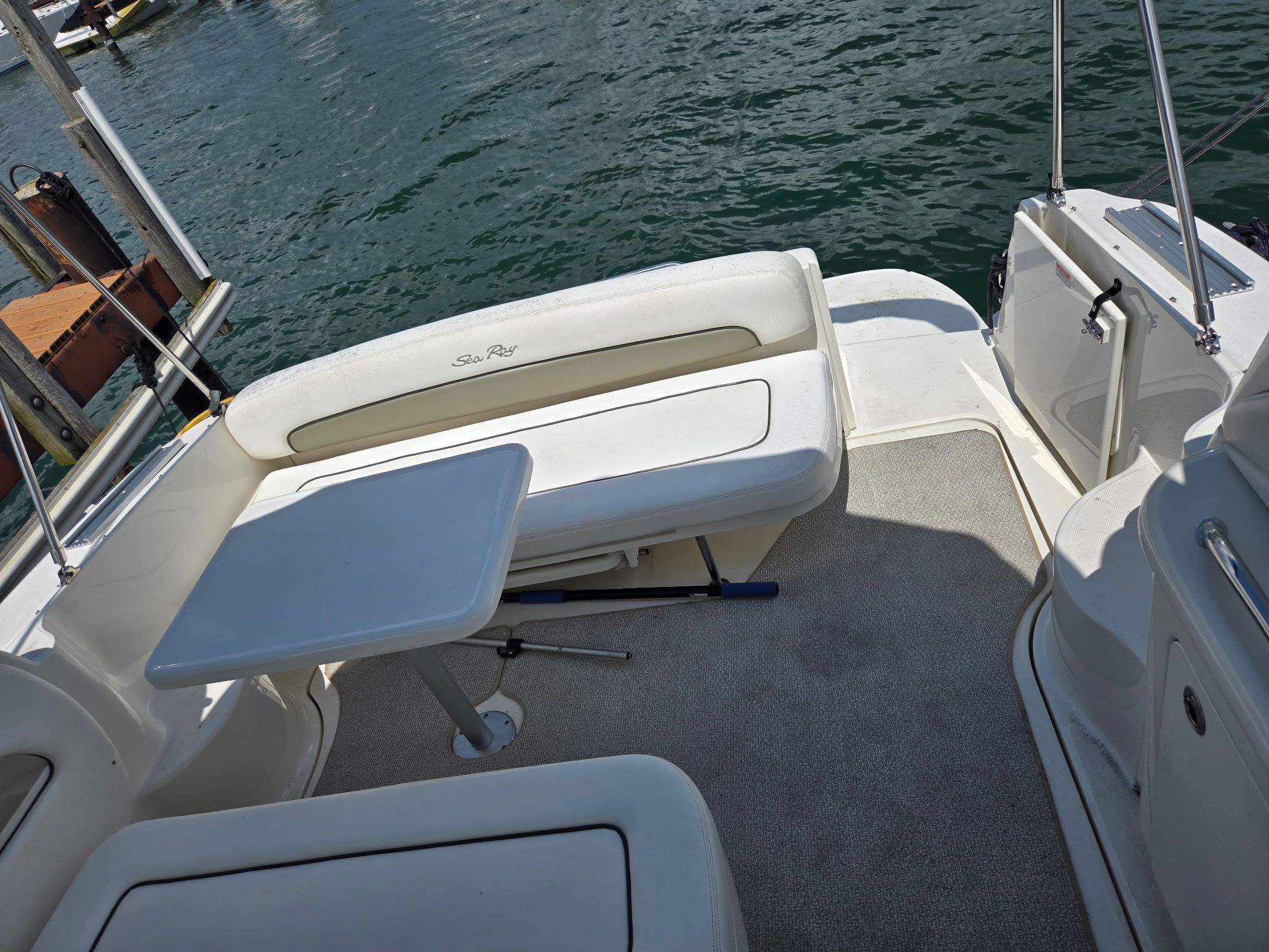 The image shows the cockpit of a 2006 Sea Ray 300 Sundancer with a bench and table.