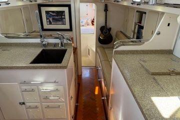 Interior of 2011 Reliance 44 yacht with kitchen, guitar, and artwork.