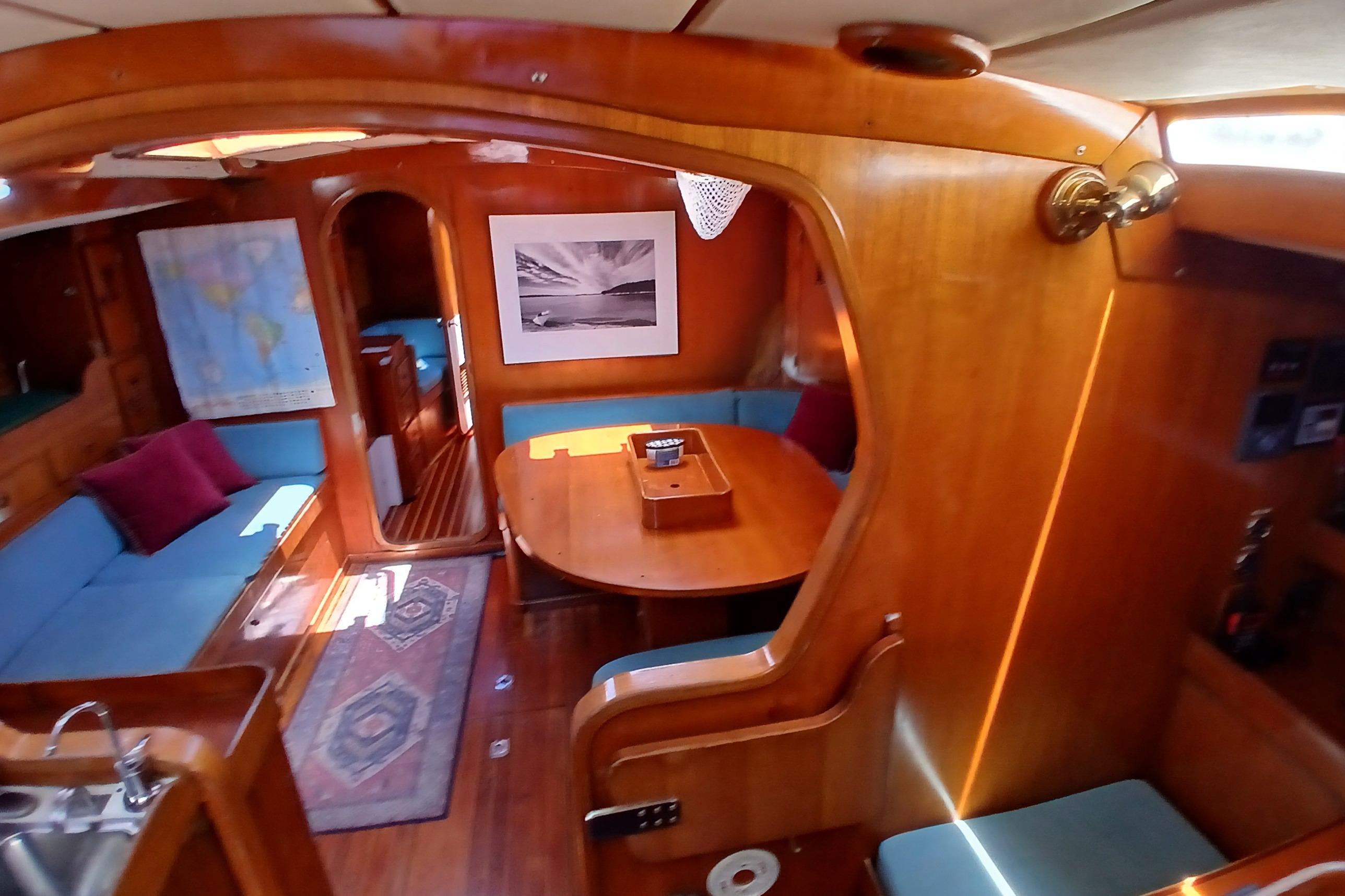 Interior of 1981 SKYE 51 yacht with wooden furnishings and cozy seating area.