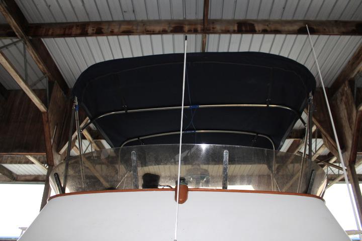 1976 CHB Double Cabin Trawler under a covered dock, featuring a dark canopy.