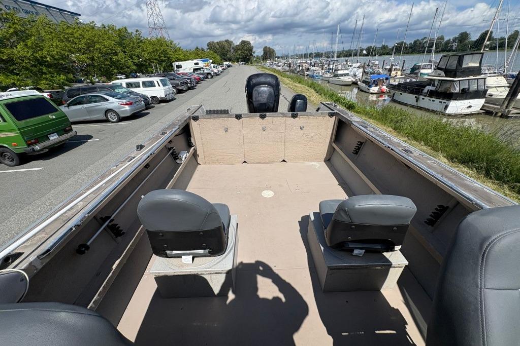 2009 Alumaweld Intruder Outboard 22 boat interior with seating, parked near marina.
