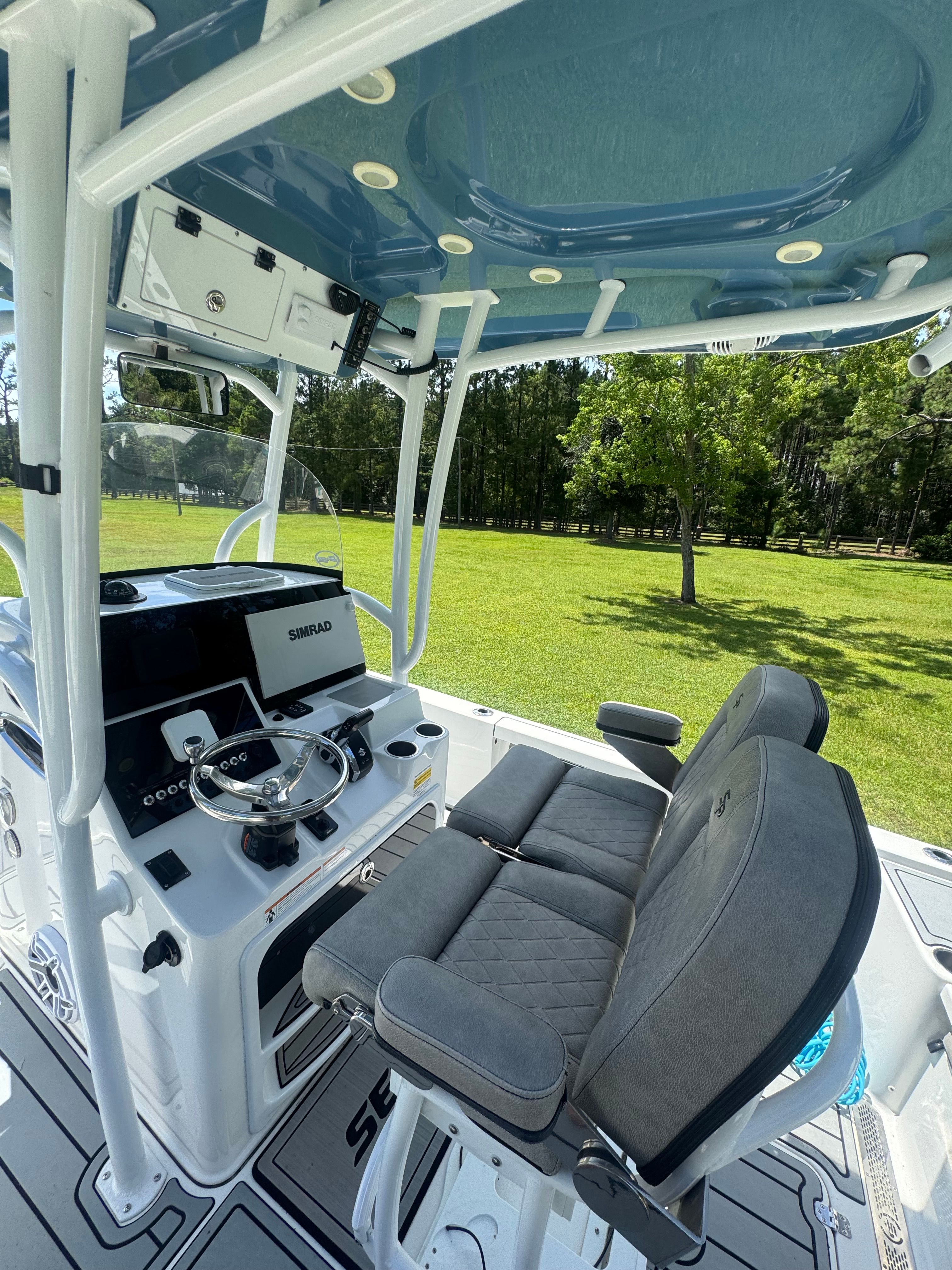 The image shows the cockpit of a 2022 Sea Pro 248 Bay boat with gray seating.