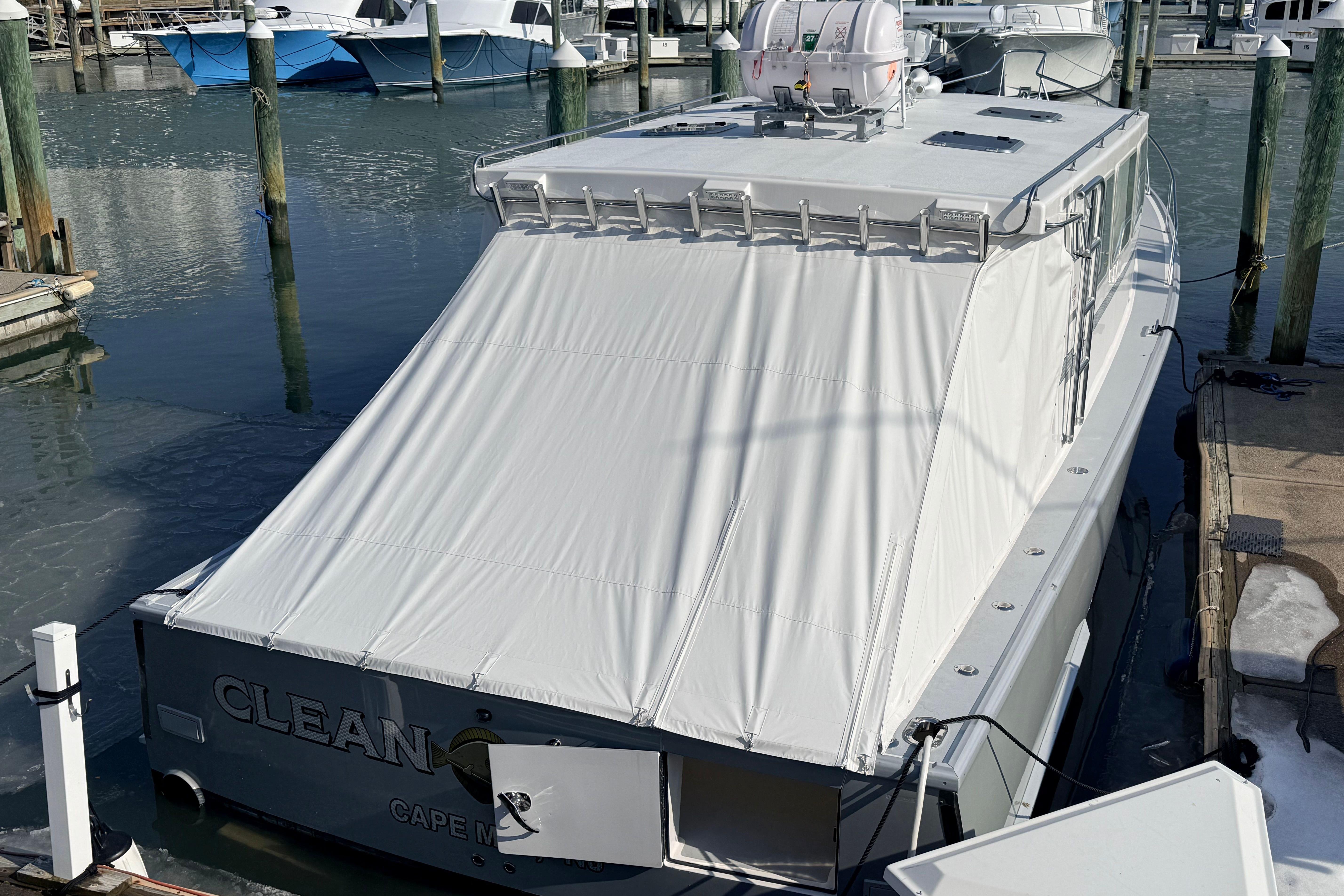 2025 Wesmac 42 boat docked with protective cover in marina.