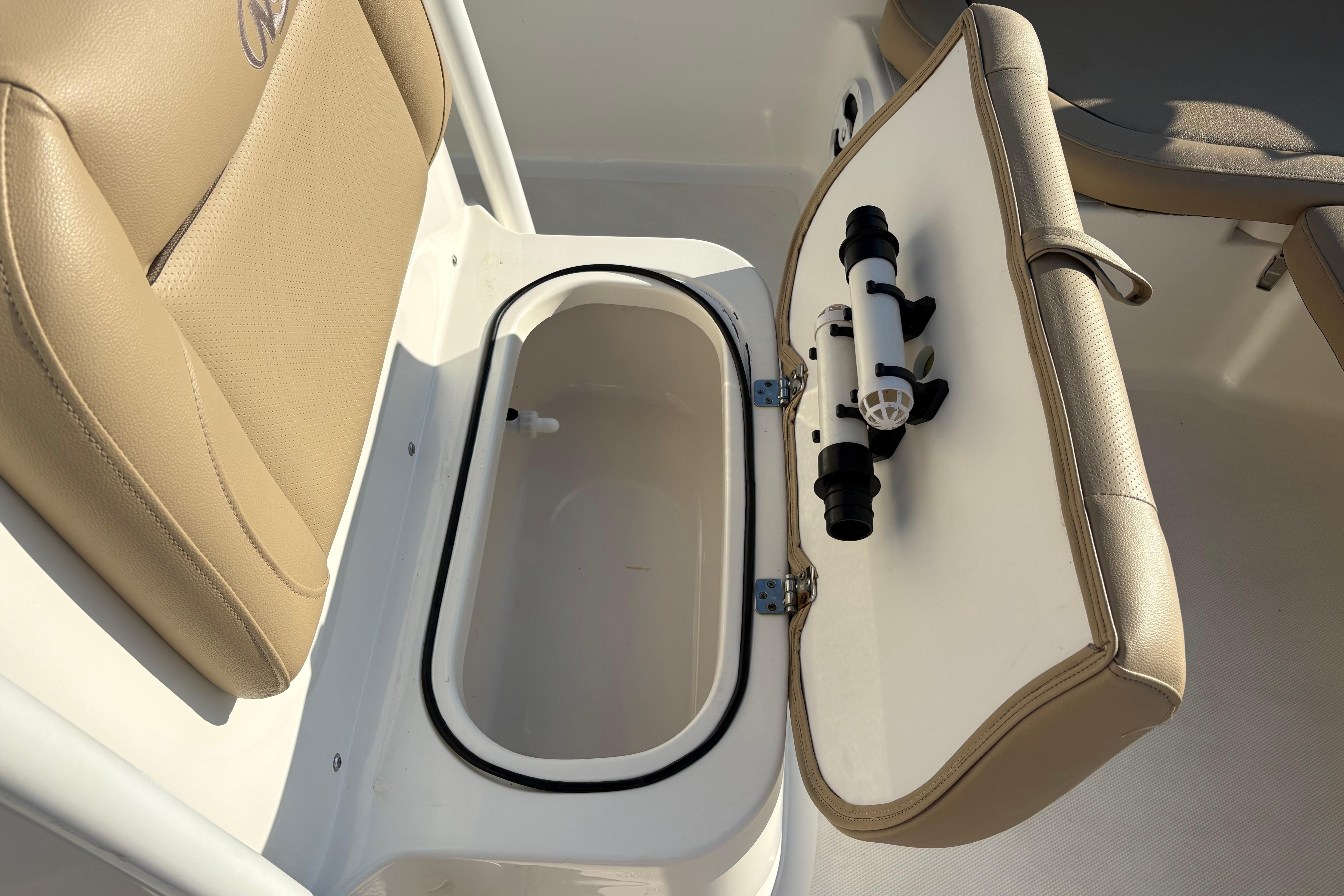 2019 NauticStar 231 Hybrid boat seat with open storage compartment and rod holder.