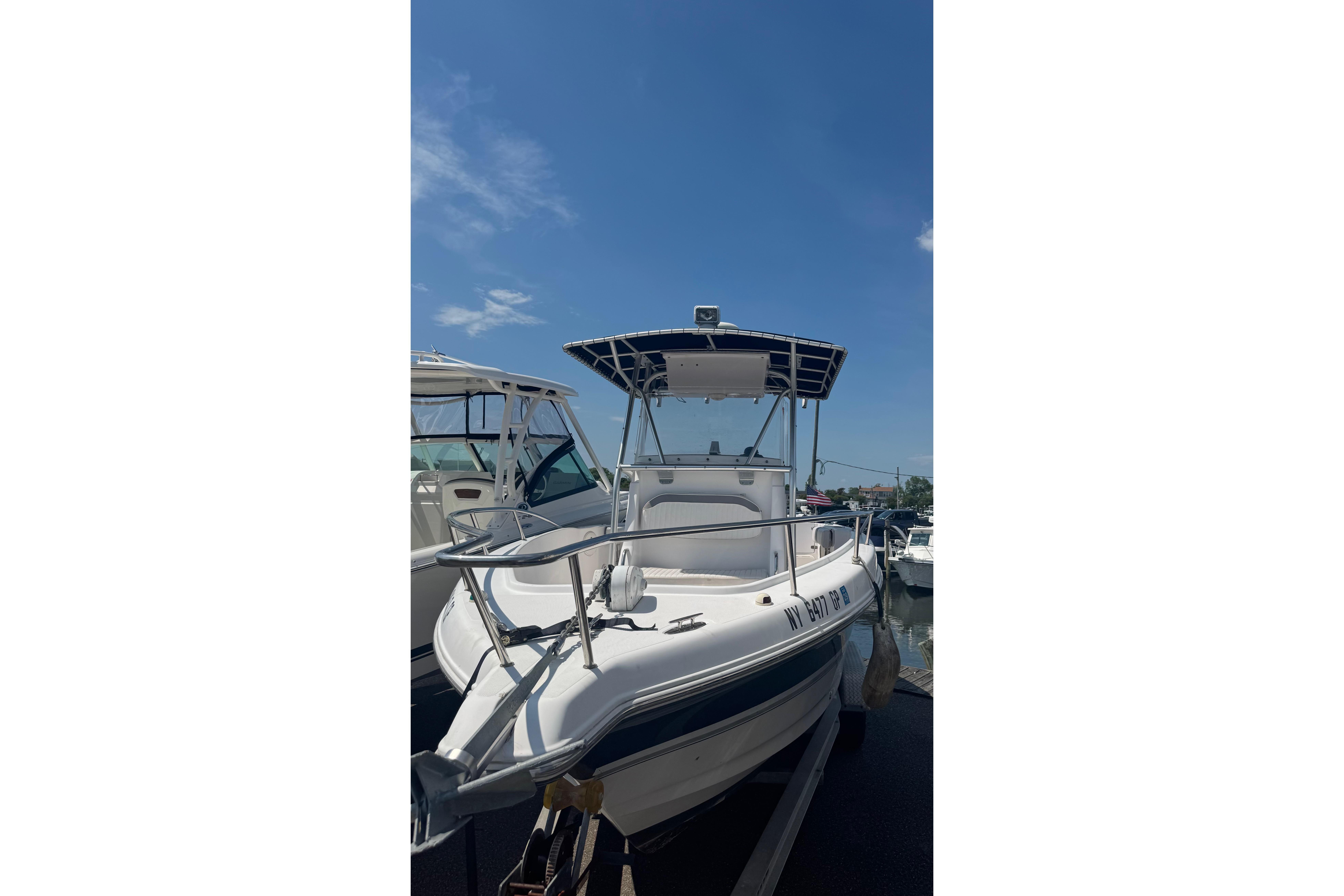 2002 Pro-Line 23 Sport boat docked under clear blue sky.