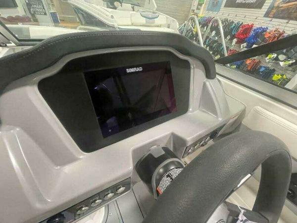 Dashboard of 2022 Chaparral 23 Surf boat with Simrad display and steering wheel.