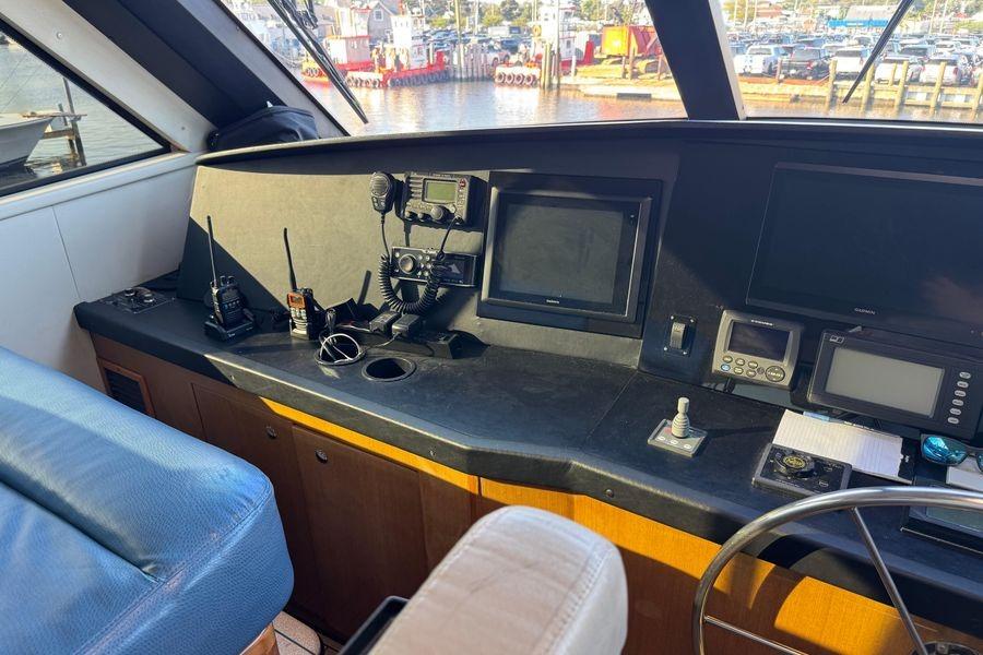 2002 Viking 61 Enclosed Bridge helm with navigation equipment and marina view.