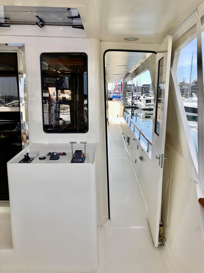 Interior view of 2027 Legend 760 Skybridge yacht, featuring sleek white design and modern controls.