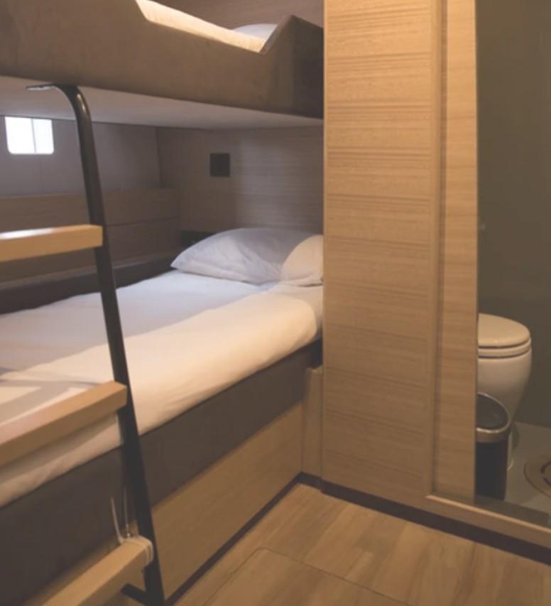 Interior of 2018 Sunreef 74C yacht with bunk beds and bathroom.