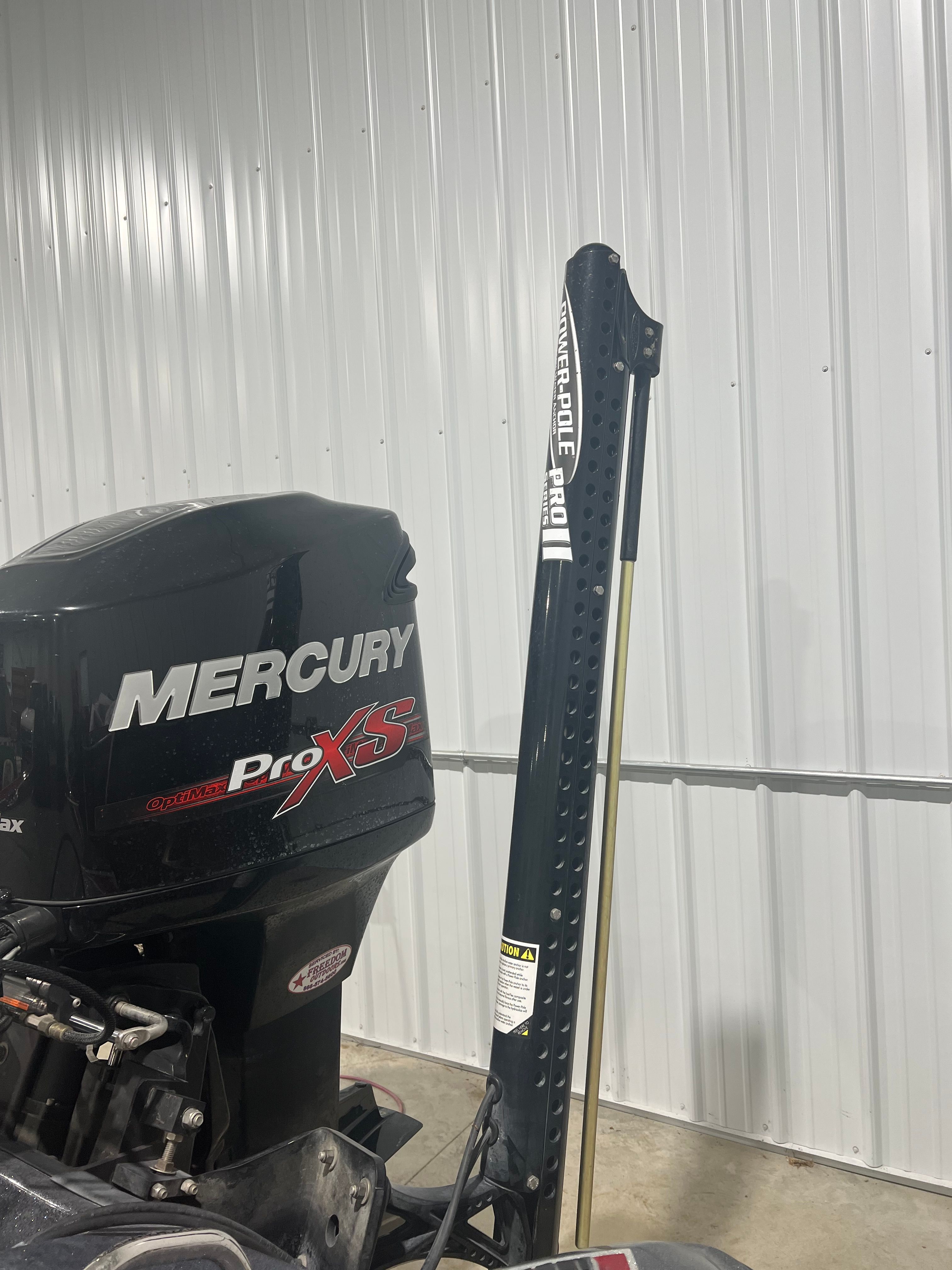 A Mercury ProXS outboard motor on a 2015 Triton 18XS boat in a storage facility.