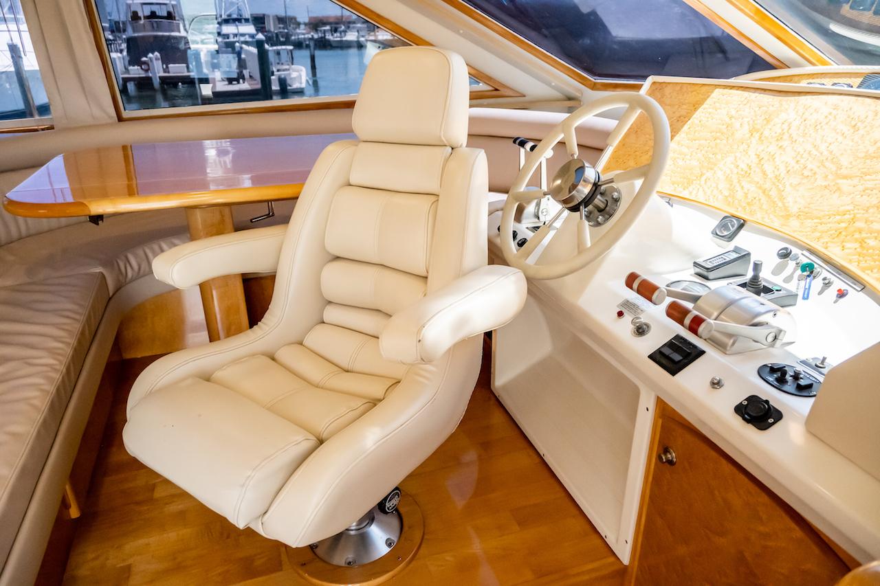 Luxurious interior of a 1999 Navigator 5800 yacht with plush captain's chair and control panel.