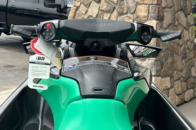 Close-up of a Sea-Doo PWC GTR 230 with green seat and black handlebars.