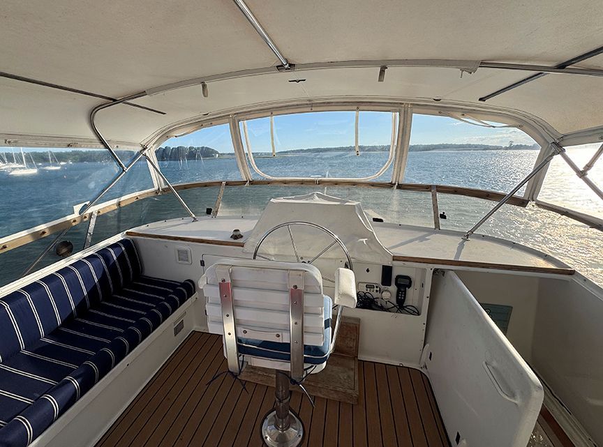 The cockpit of a 1961 Burger 63 yacht with blue and white striped seating.