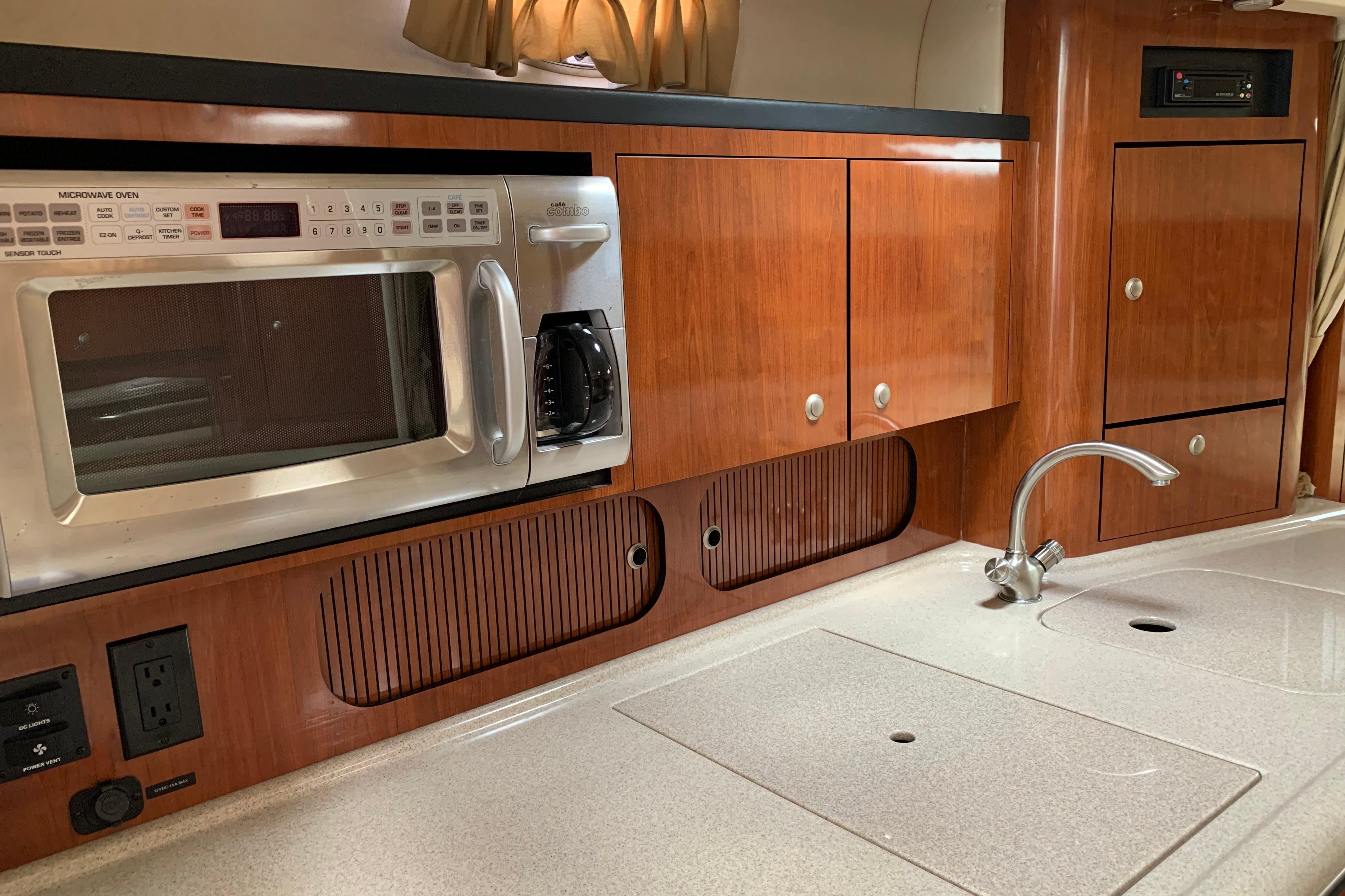 2007 Sea Ray 340 Sundancer galley with microwave, wooden cabinets, and sleek countertop.