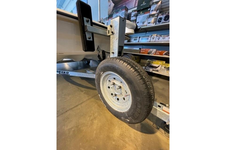 2026 Mako Pro Skiff 13 CC trailer wheel in a showroom setting.