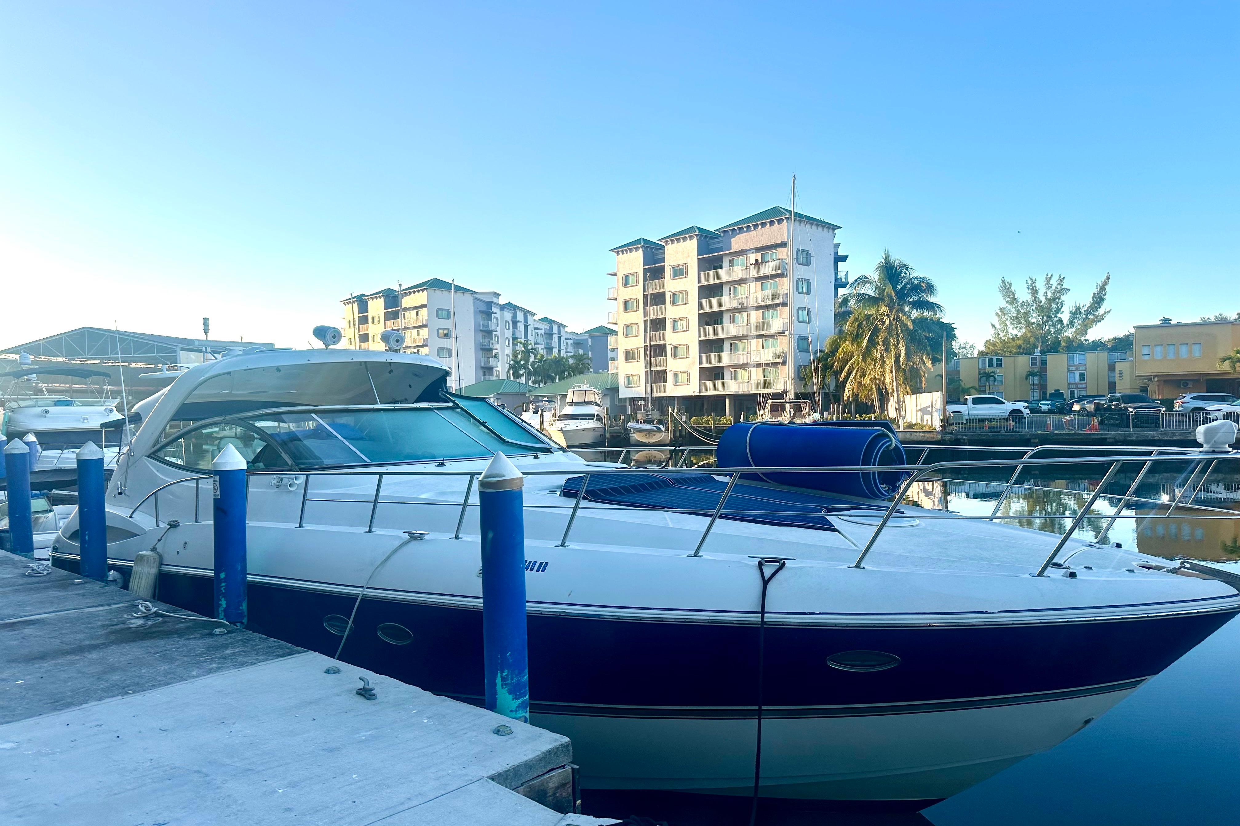 2005 Cruisers Yachts 500 Express docked in a marina with buildings in the background.