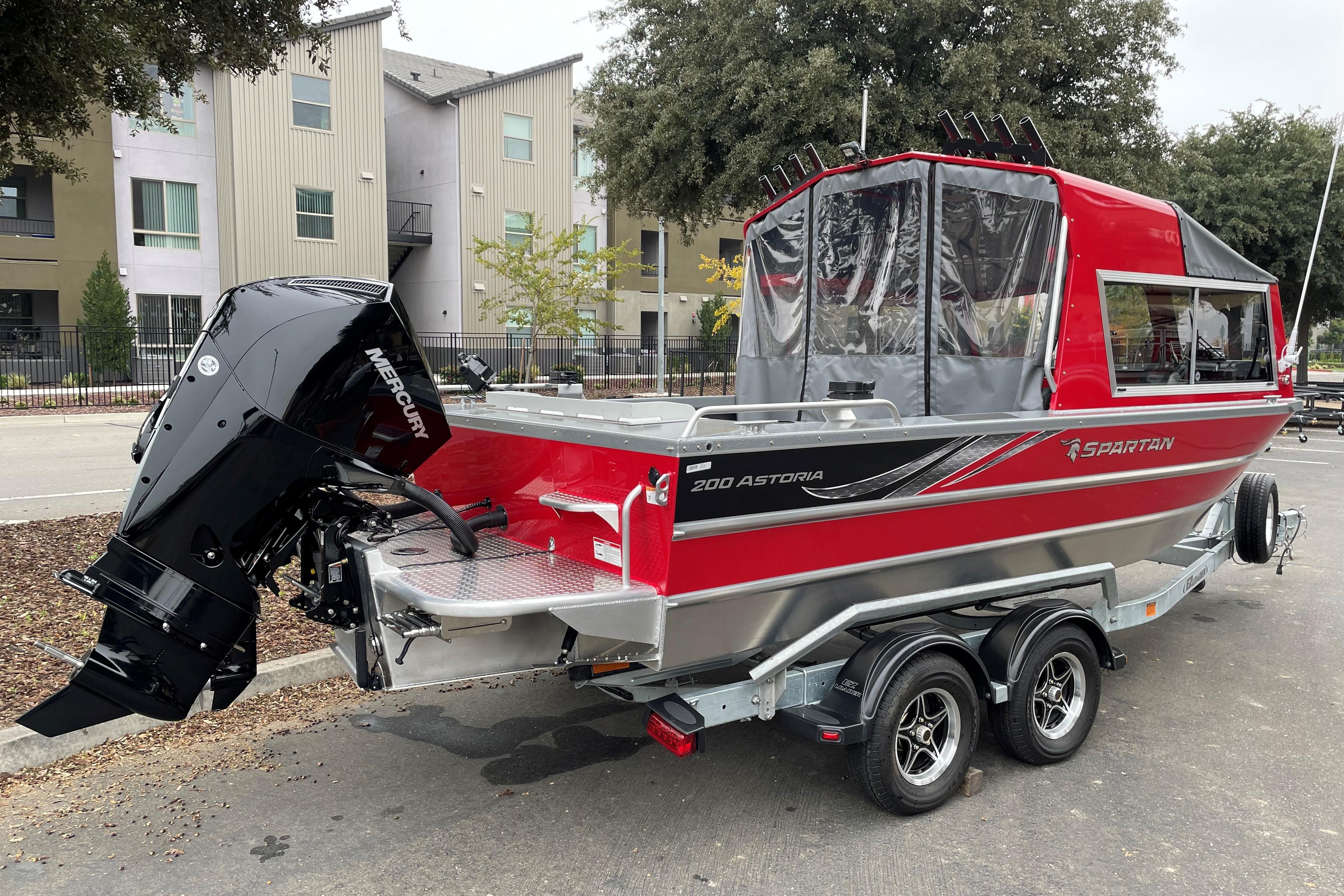 2024 Spartan 200 Astoria boat, red and silver, on trailer with Mercury outboard motor.