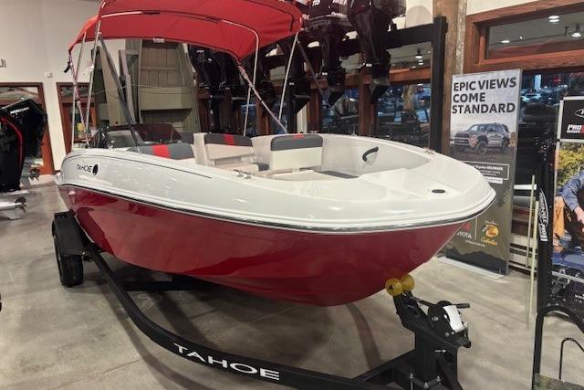 2026 Tahoe T18 boat with red hull and canopy on display in showroom.