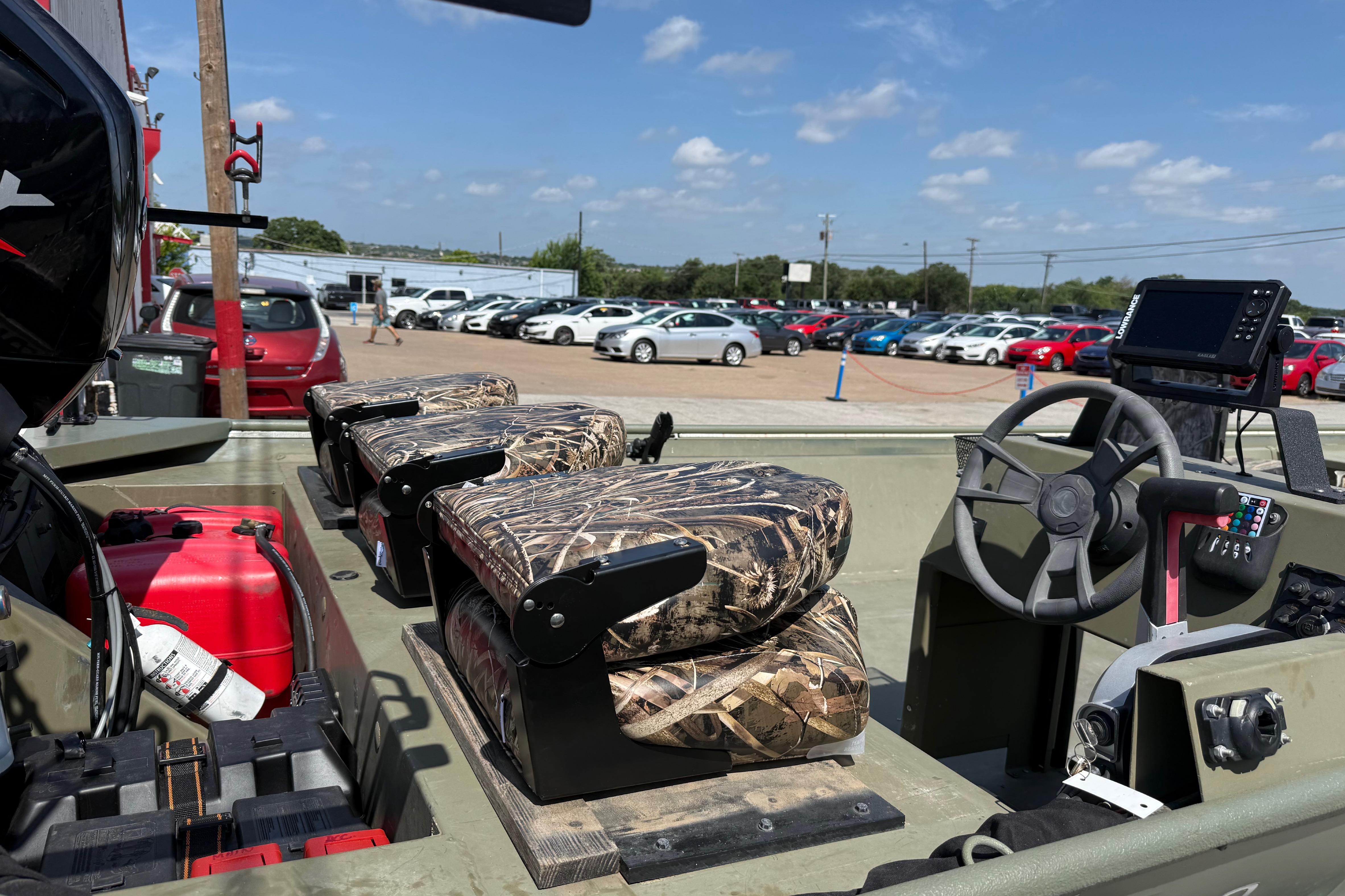 The image shows the interior of a Lowe Roughneck 2070 Big River boat with camouflage seats.