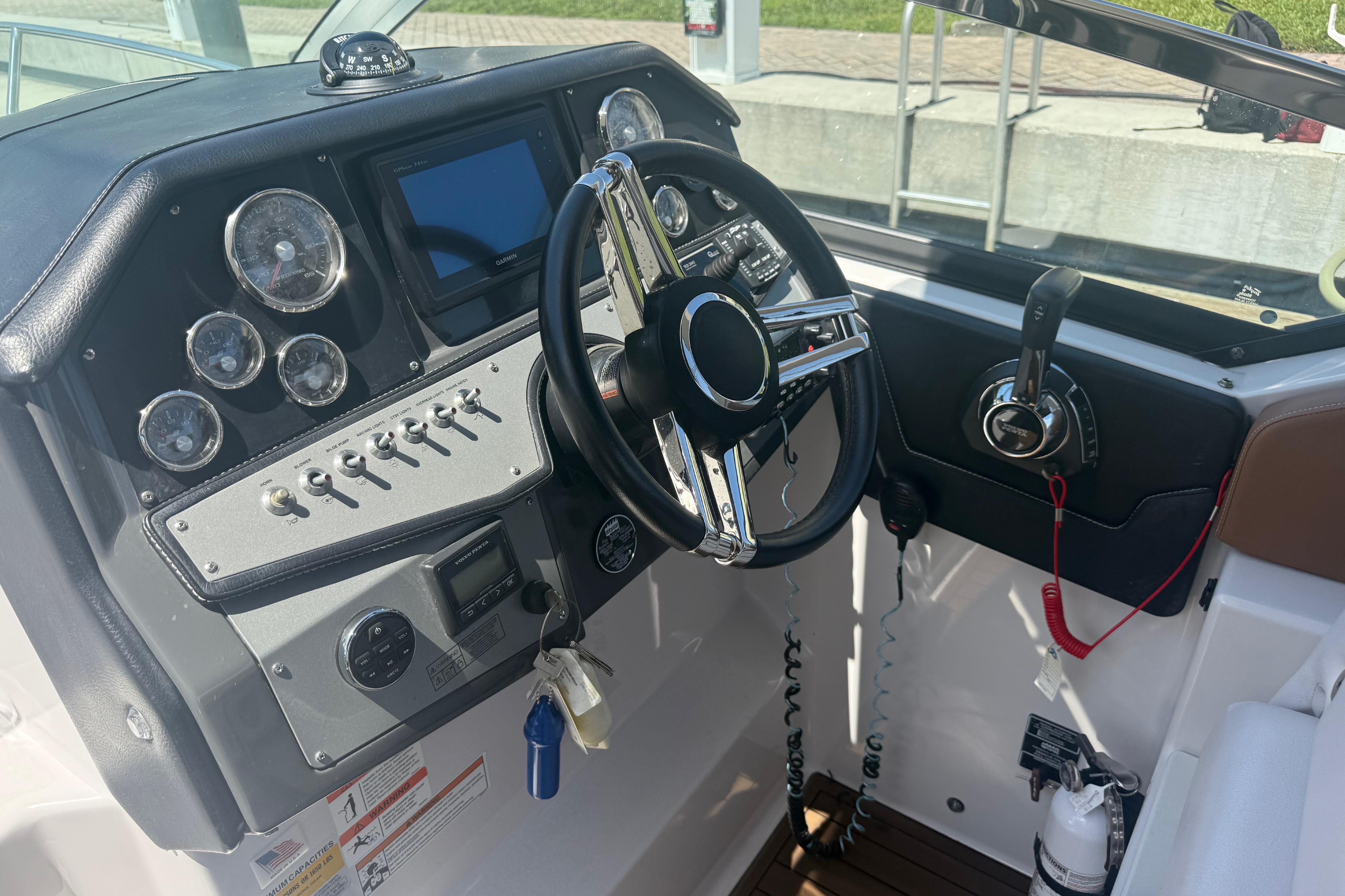 2017 Four Winns V275 boat dashboard with steering wheel, gauges, and controls.