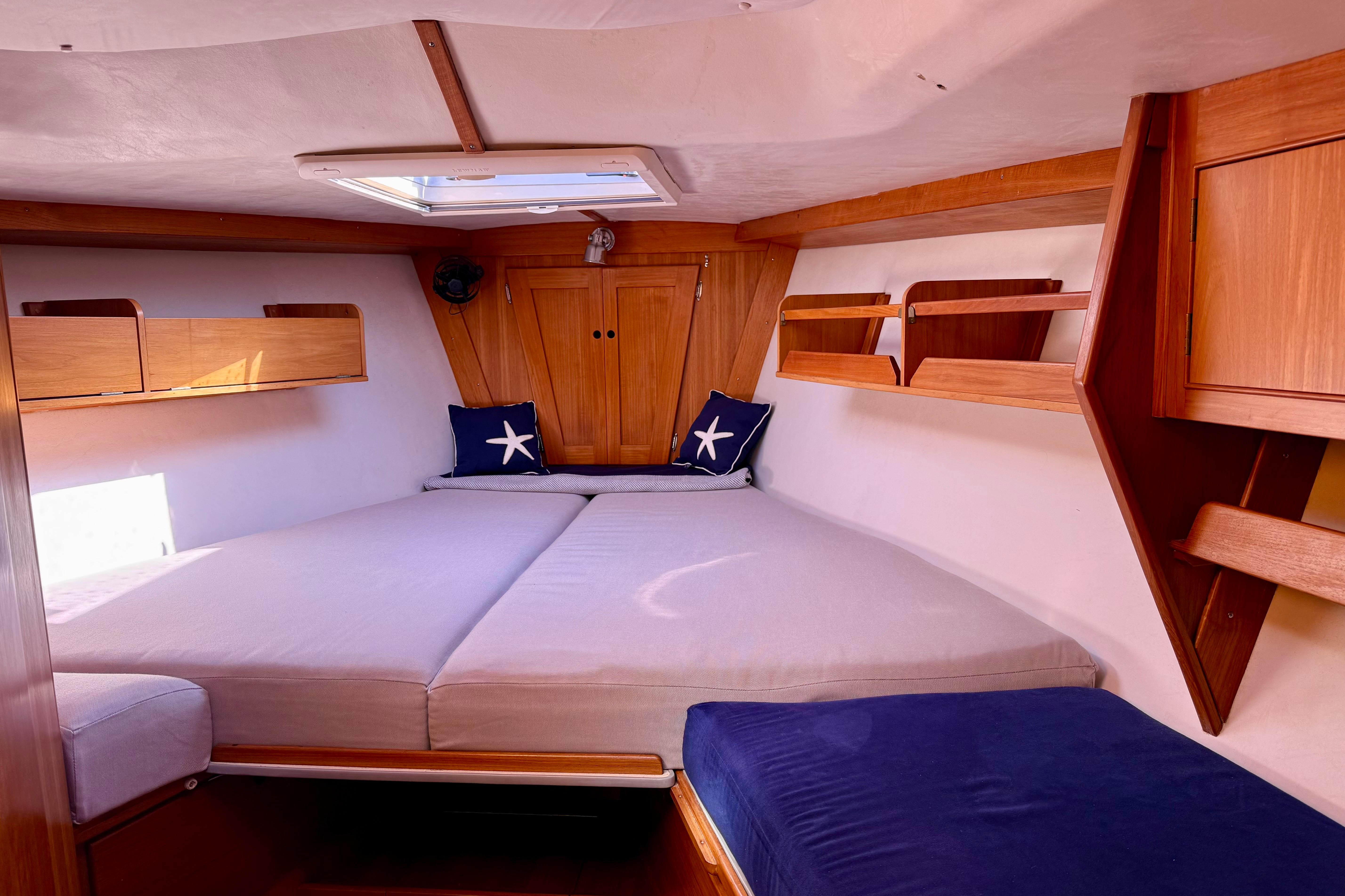 Cozy cabin interior of a 1991 J/Boats model, featuring wooden accents and nautical decor.