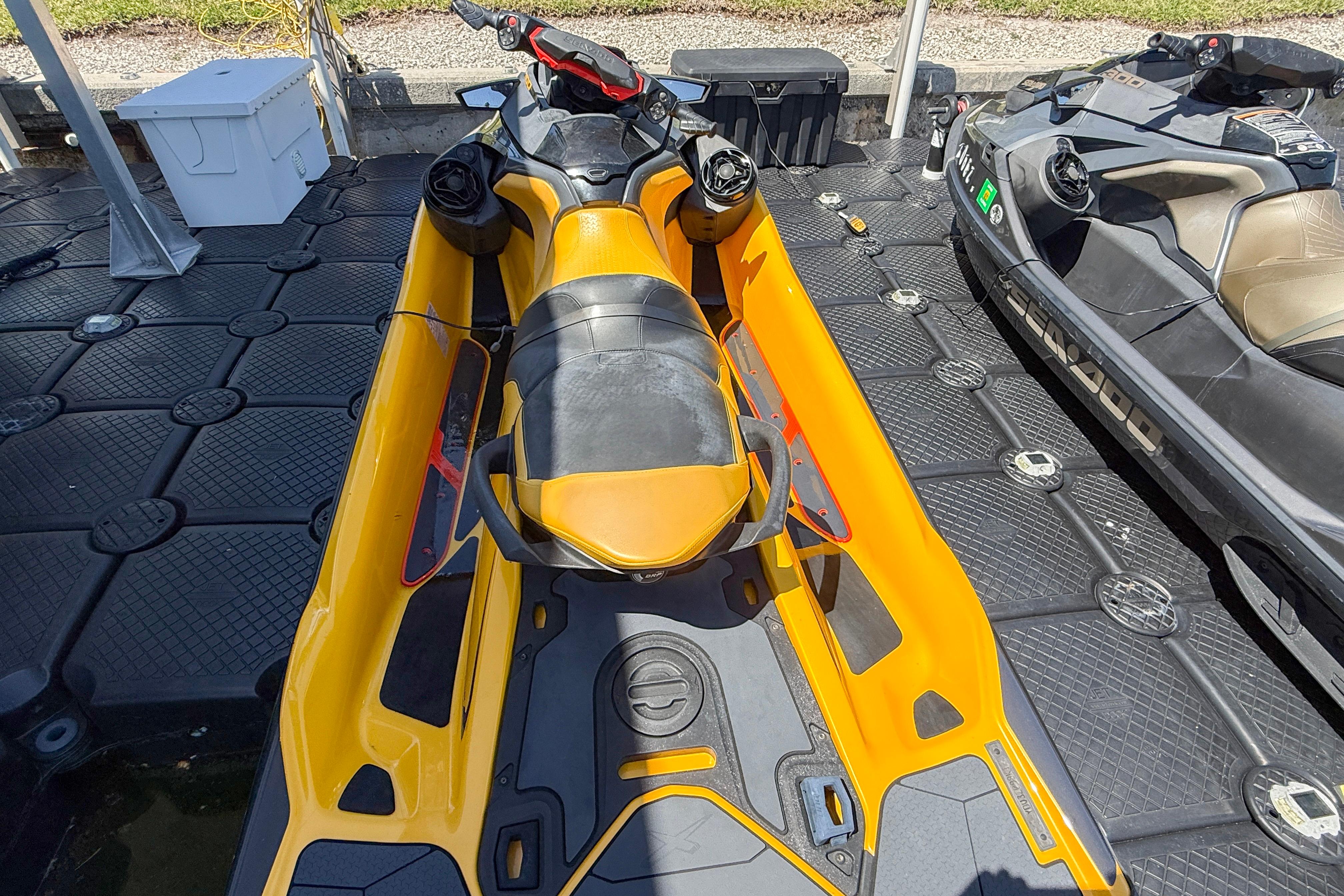 2022 Sea Doo RXTX 300 jet ski in vibrant yellow, docked on a floating platform.