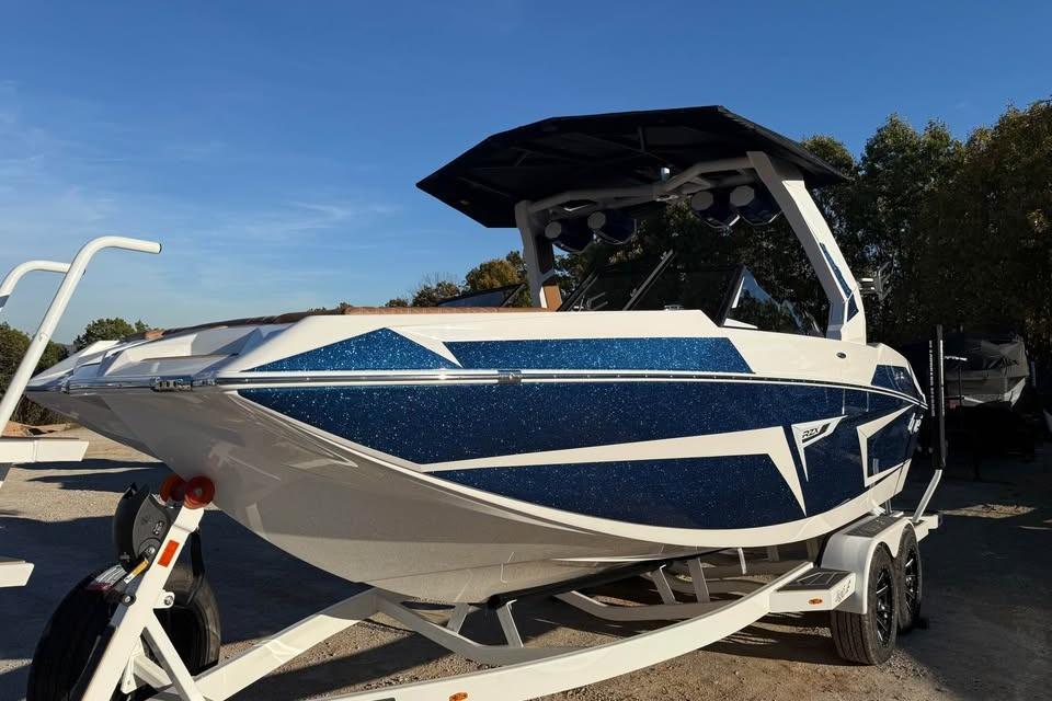 2026 Tigé 22RZX boat with blue and white design on a trailer, outdoors.