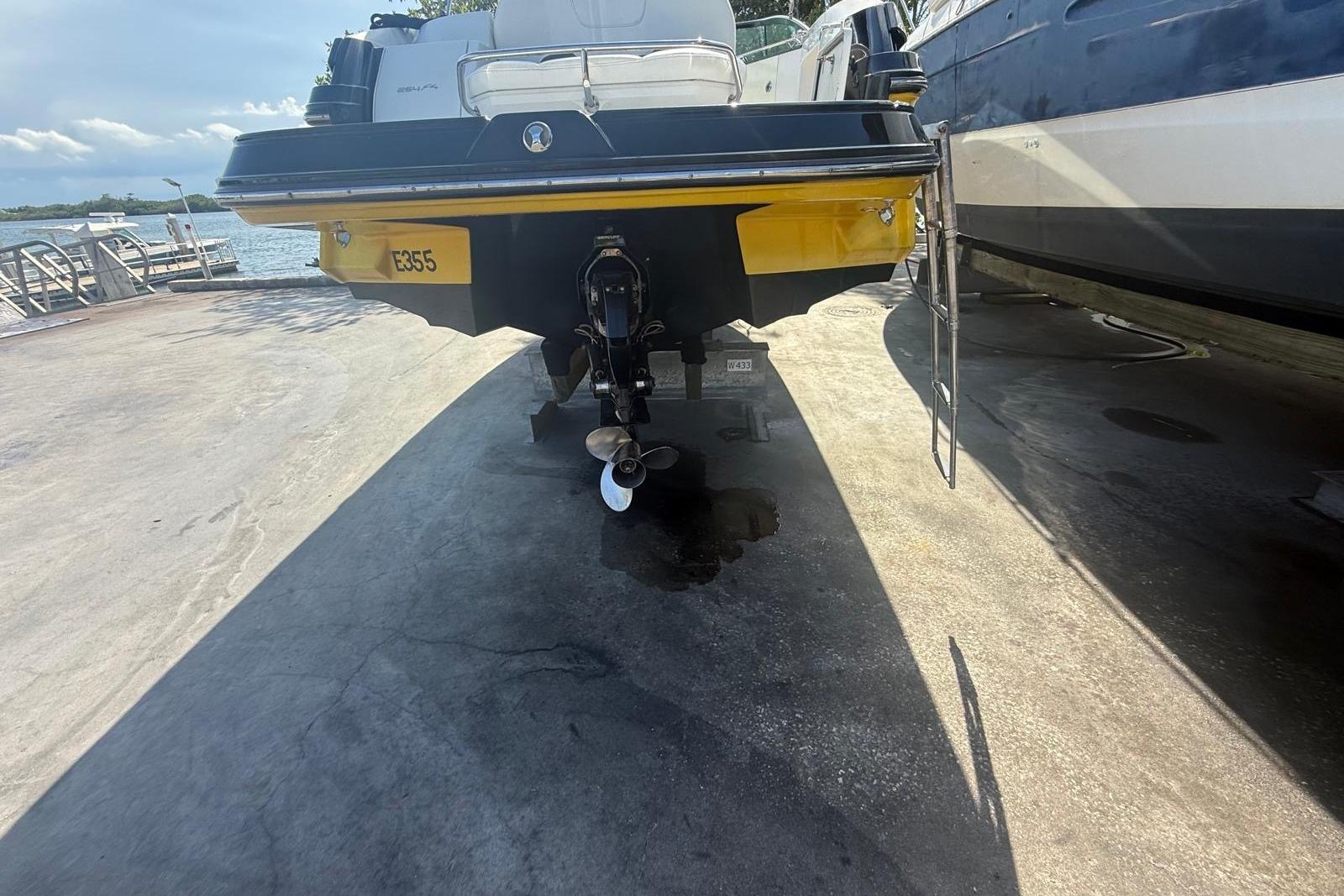 Rear view of a 2015 Monterey 264FS boat on a dock, showing the propeller and ladder.