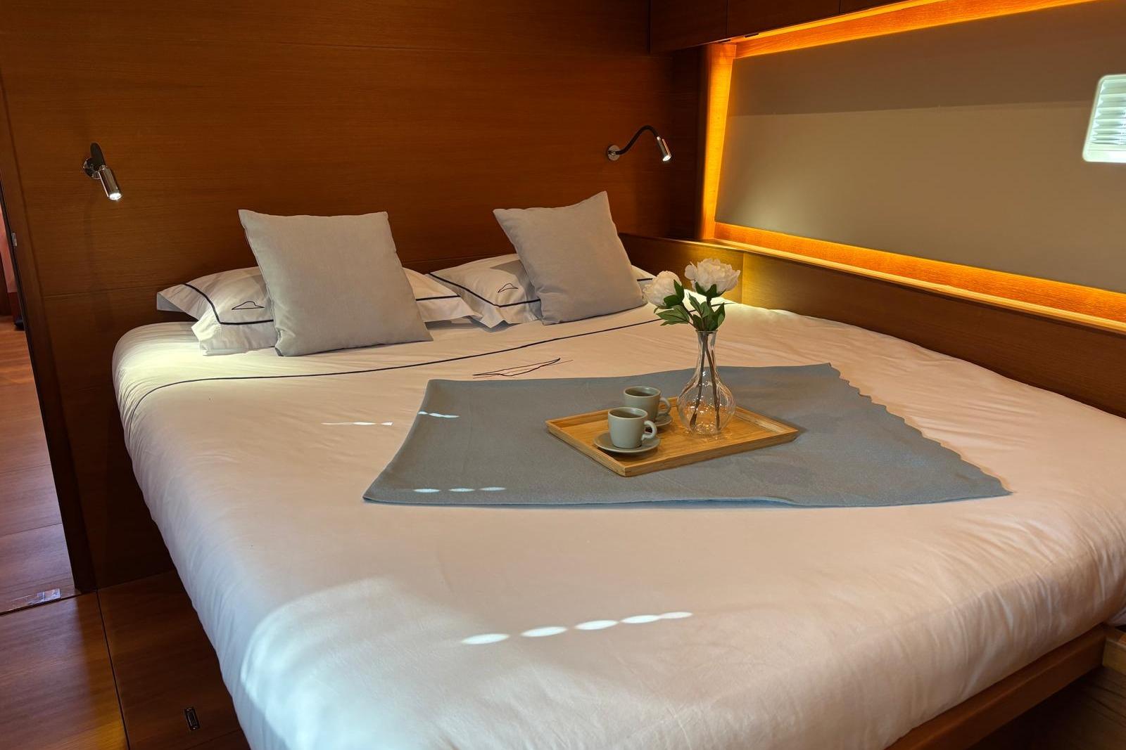 Luxurious bedroom in 2022 Solaris 55 yacht with cozy bedding and elegant decor.