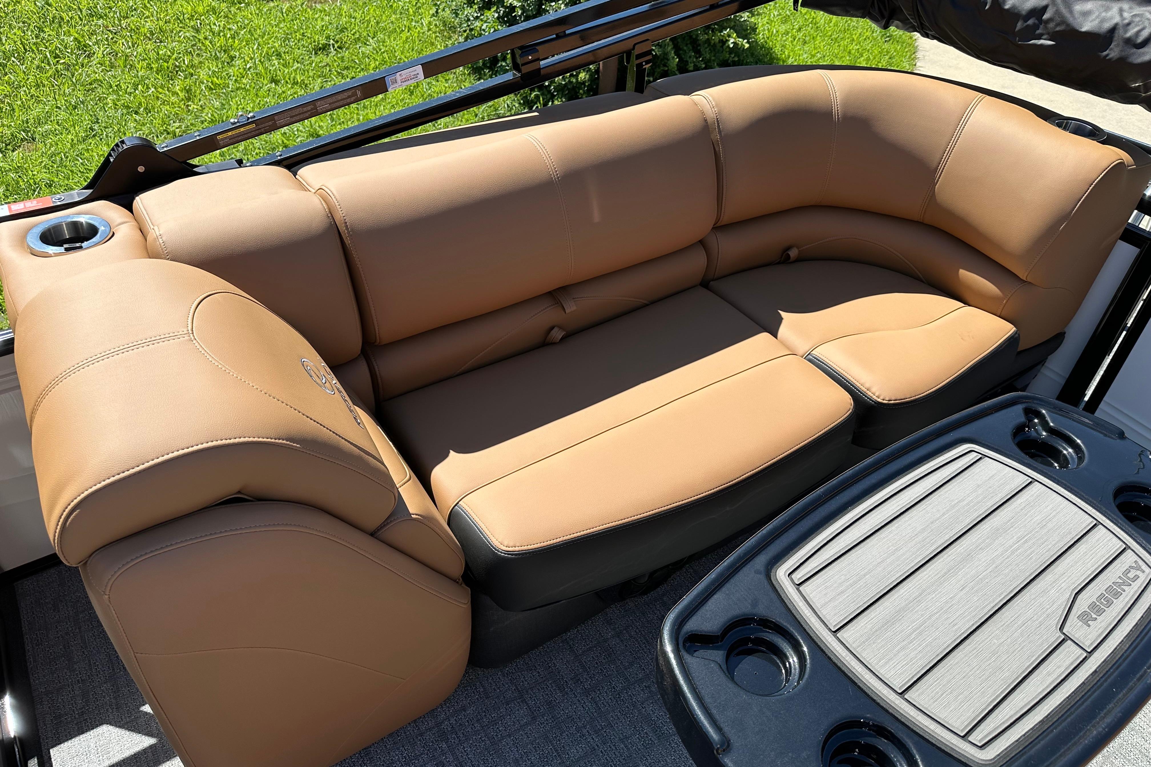 Luxurious tan seating on 2026 Regency 230 DL boat, featuring cup holders and sleek design.