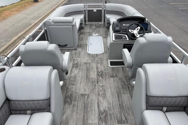 2025 Ranger Reata 243C pontoon boat interior with gray seating and wood-style flooring.