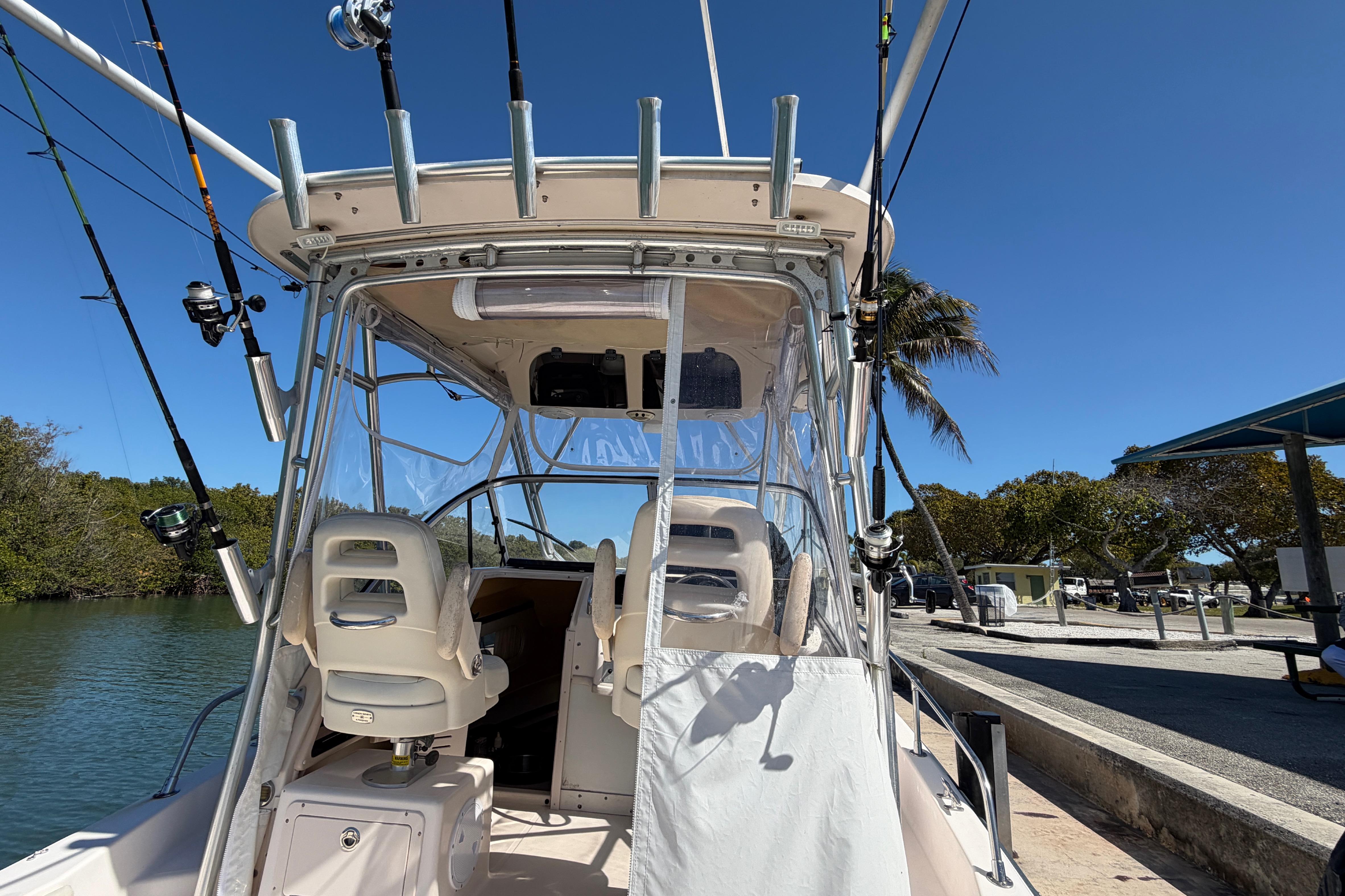 2006 Grady-White Sailfish 282 boat docked, featuring fishing rods and seating under clear skies.