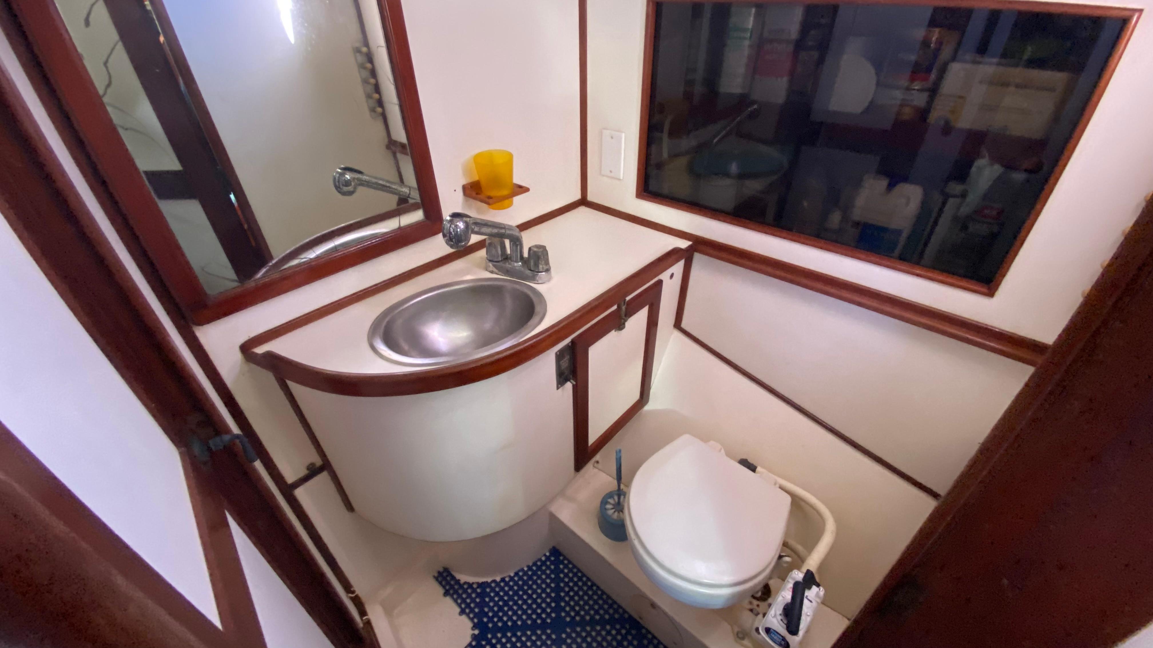 Compact bathroom in 1987 Catalina Morgan 43 yacht with sink and toilet.