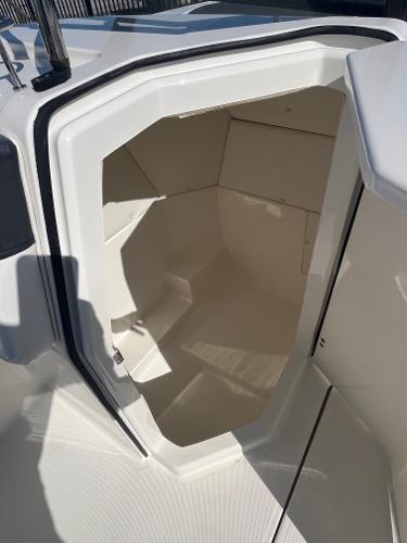 2021 Bayliner DX 2200 boat storage compartment, open and empty, with white interior.