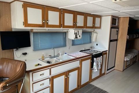 Interior of a 1994 PlayCraft 5215 RV kitchen with cabinets and appliances.