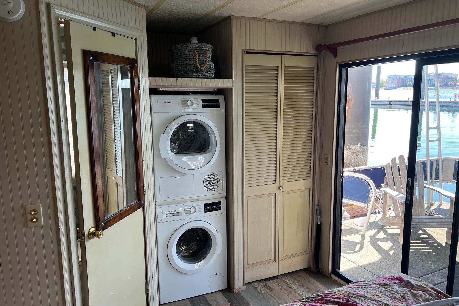 Interior of a 1993 Sumerset houseboat with stacked washer and dryer, near sliding glass door.