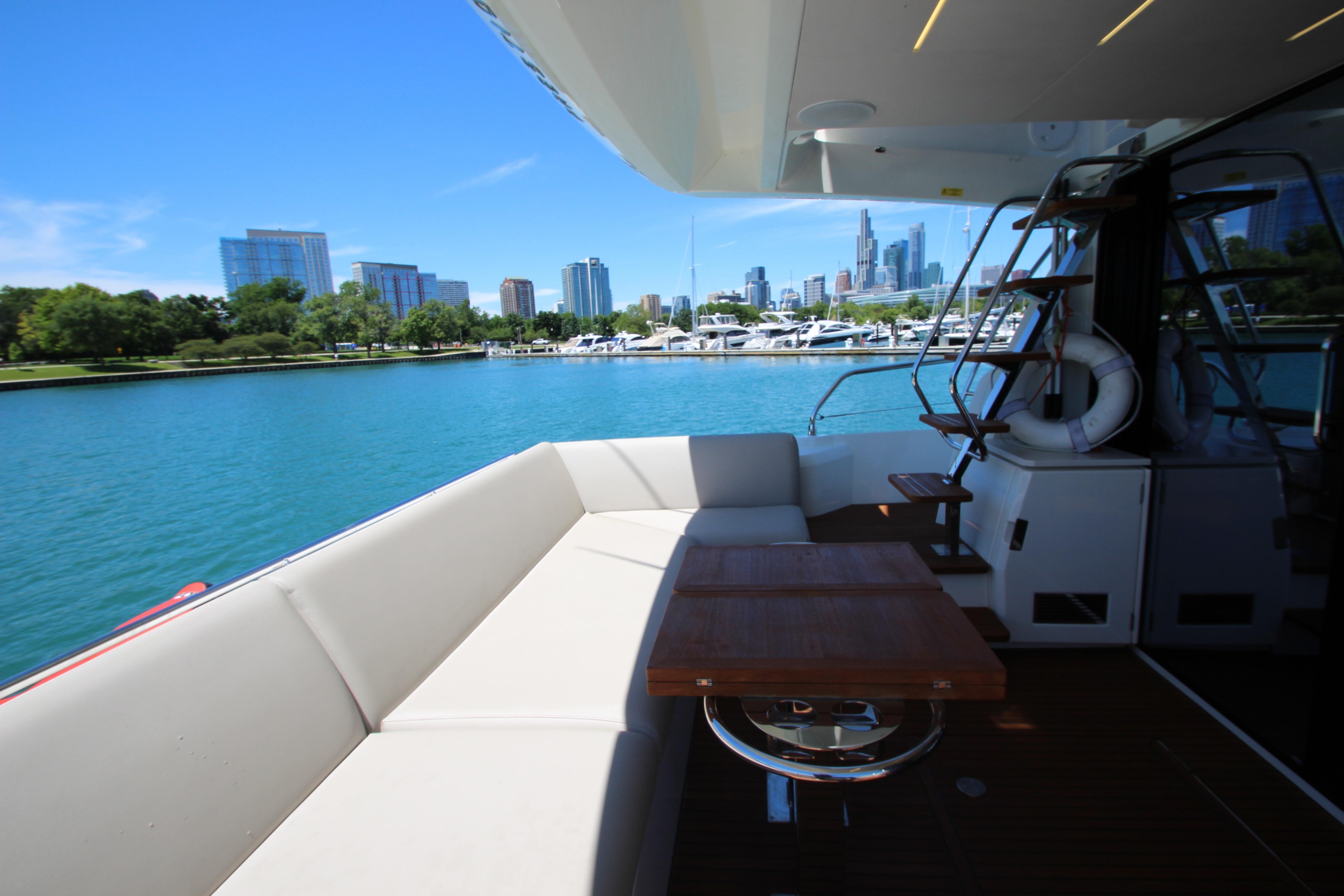 Luxurious 2022 Prestige 520 yacht with city skyline and marina view.