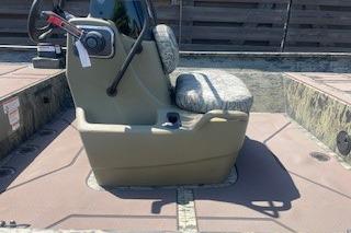 2026 Tracker Grizzly 2072 CC boat interior with steering console and cushioned seat.