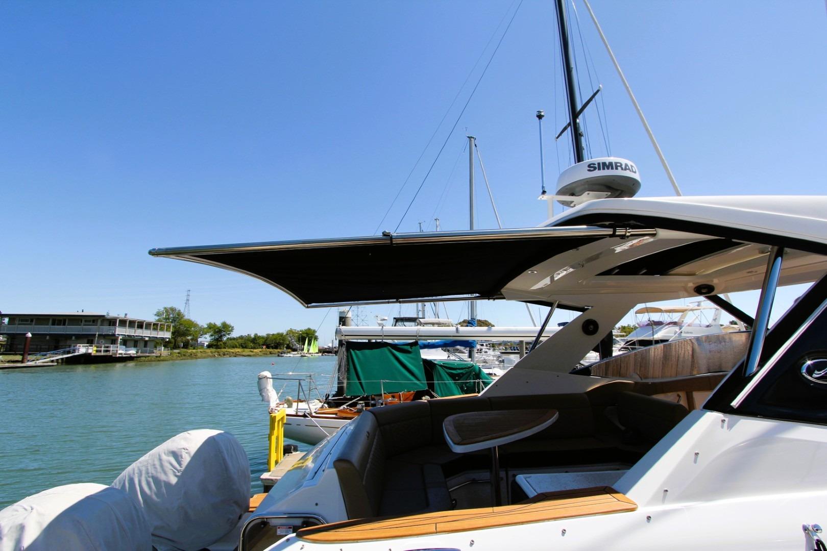 2021 Sea Ray Sundancer 320 Outboard docked, featuring sleek design and spacious seating area.