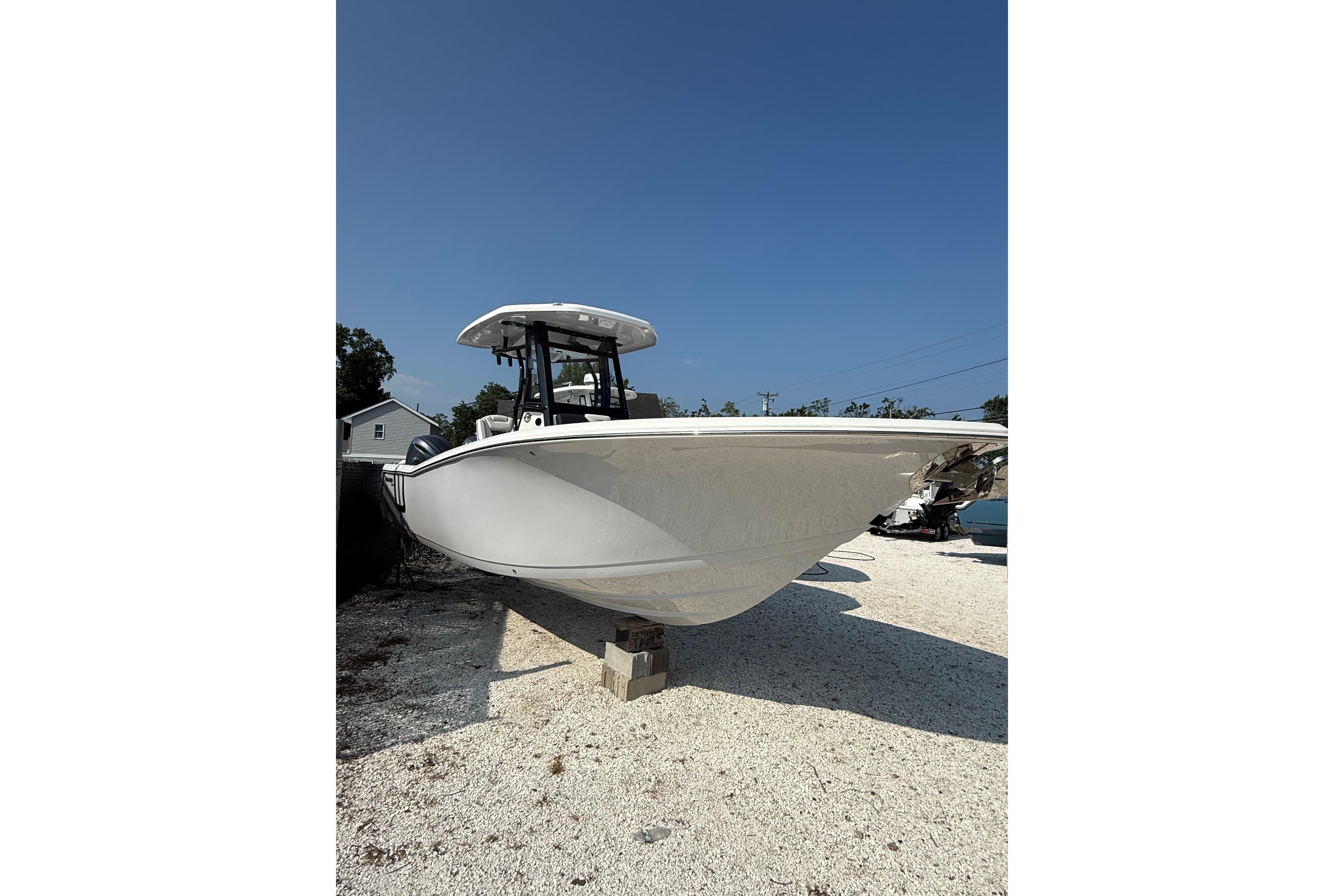 2026 Tidewater 256 CC Adventure boat on display under clear blue sky.