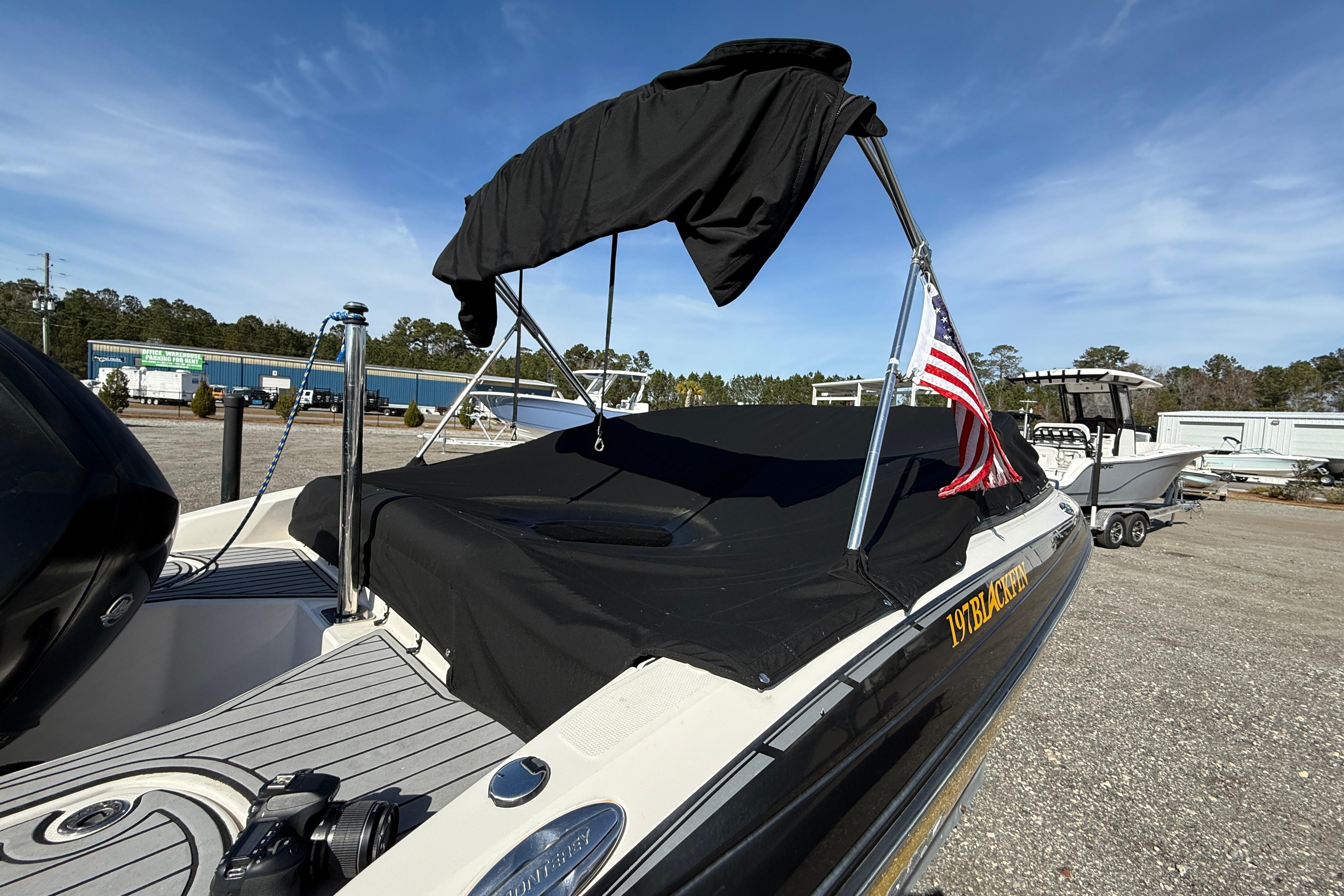 2014 Monterey 197 Blackfin boat with American flag, parked outdoors under clear sky.