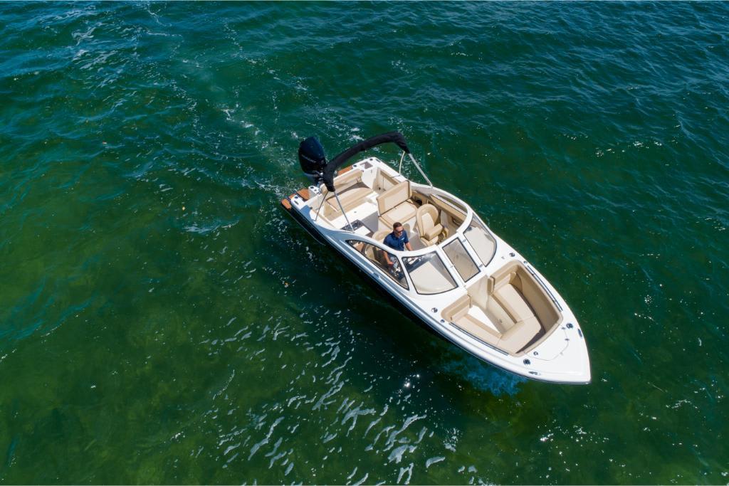 2023 Scout 240 Dorado boat cruising on clear blue water.