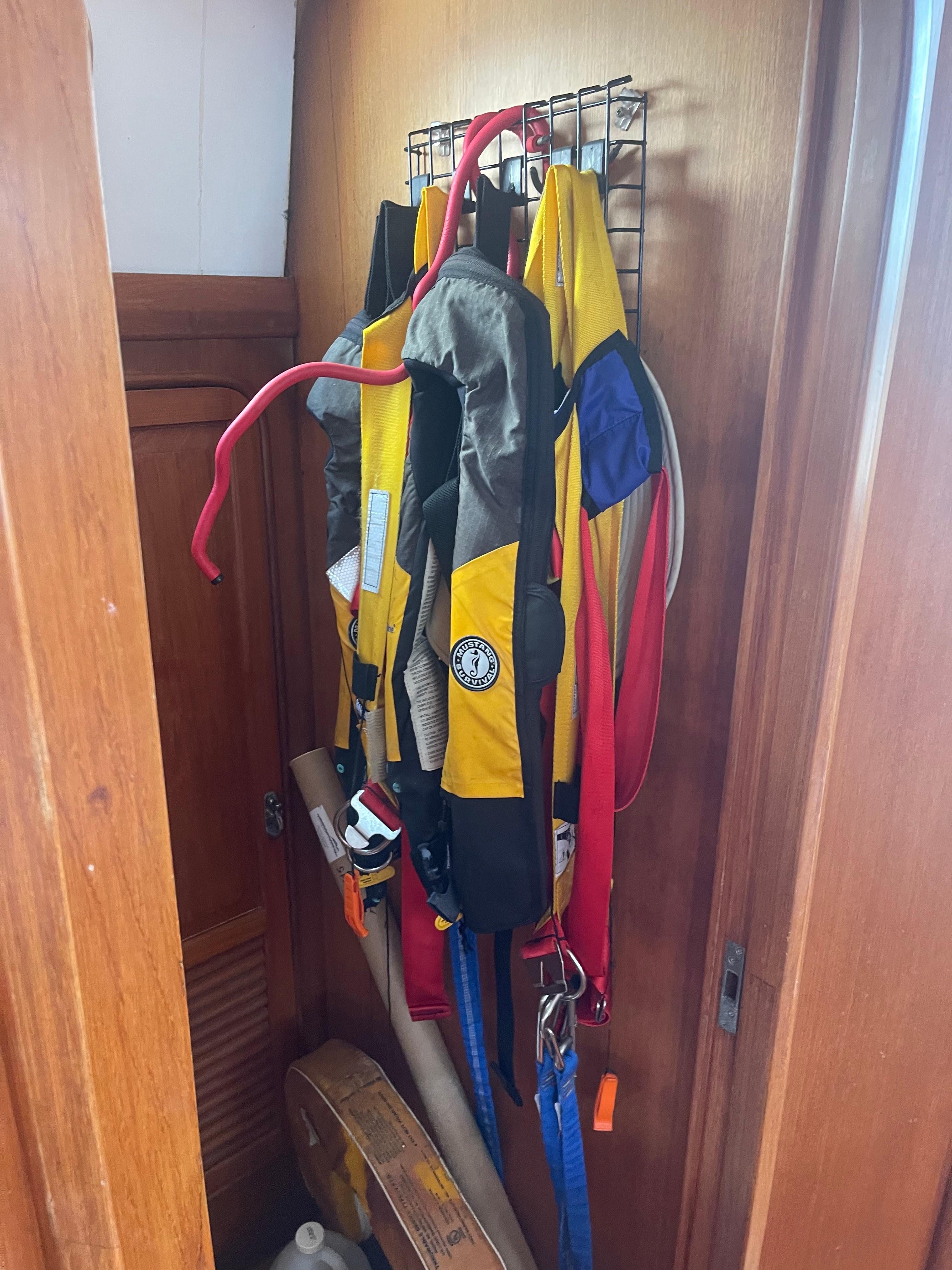 Life jackets hanging in a wooden closet on a 1995 Passport 47 AC Plan B sailboat.