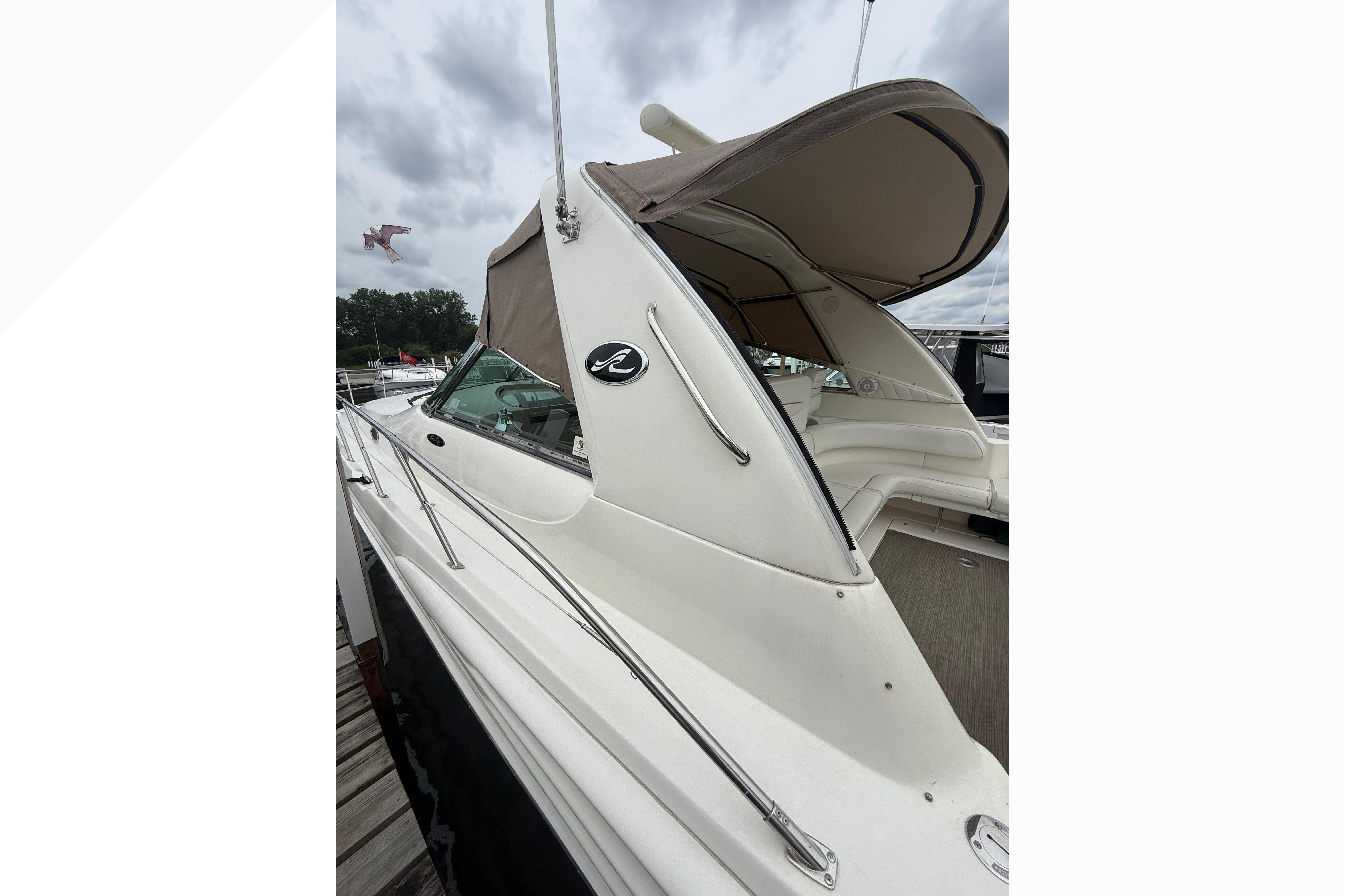 1998 Sea Ray Sundancer 400 yacht with beige canopy, docked under cloudy skies.